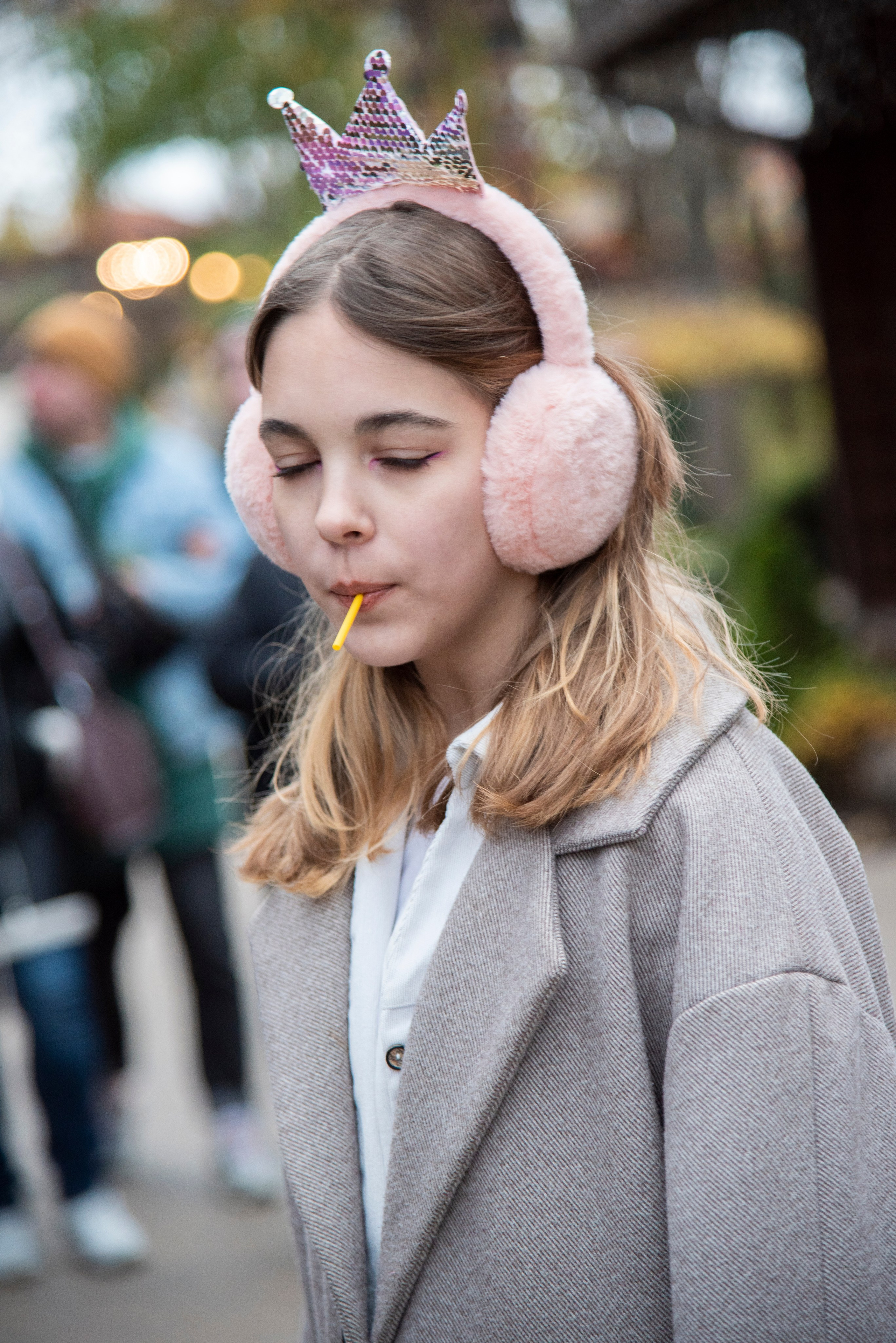 Девушка в наушниках, в сером пальто. парк лога. осень
