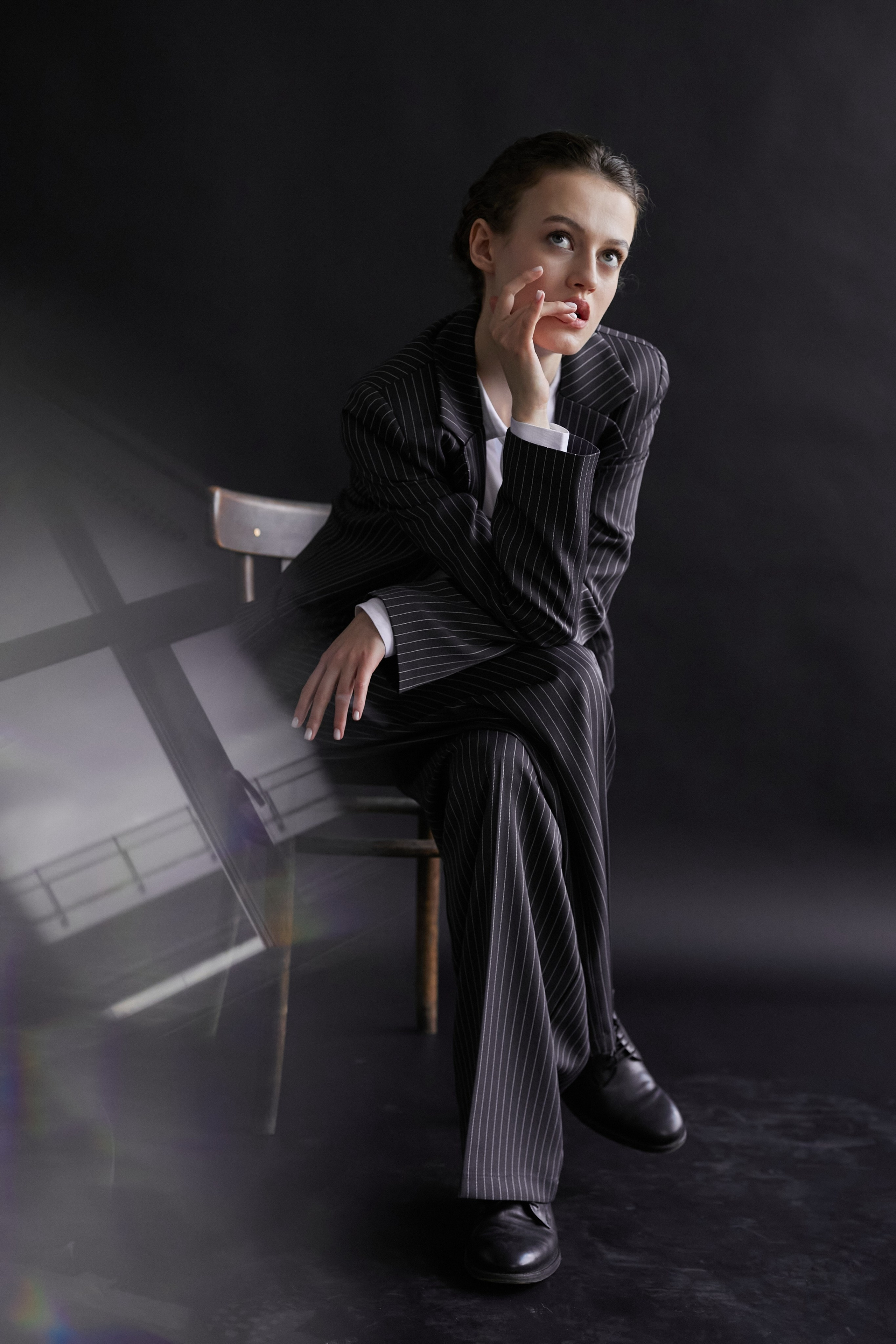 Фотограф в Москве. Студия. Студийный портрет. Девушка в пиджаке. Девушка на стуле на черном фоне. Красивая девушка в мужском костюме. Женский портрет.