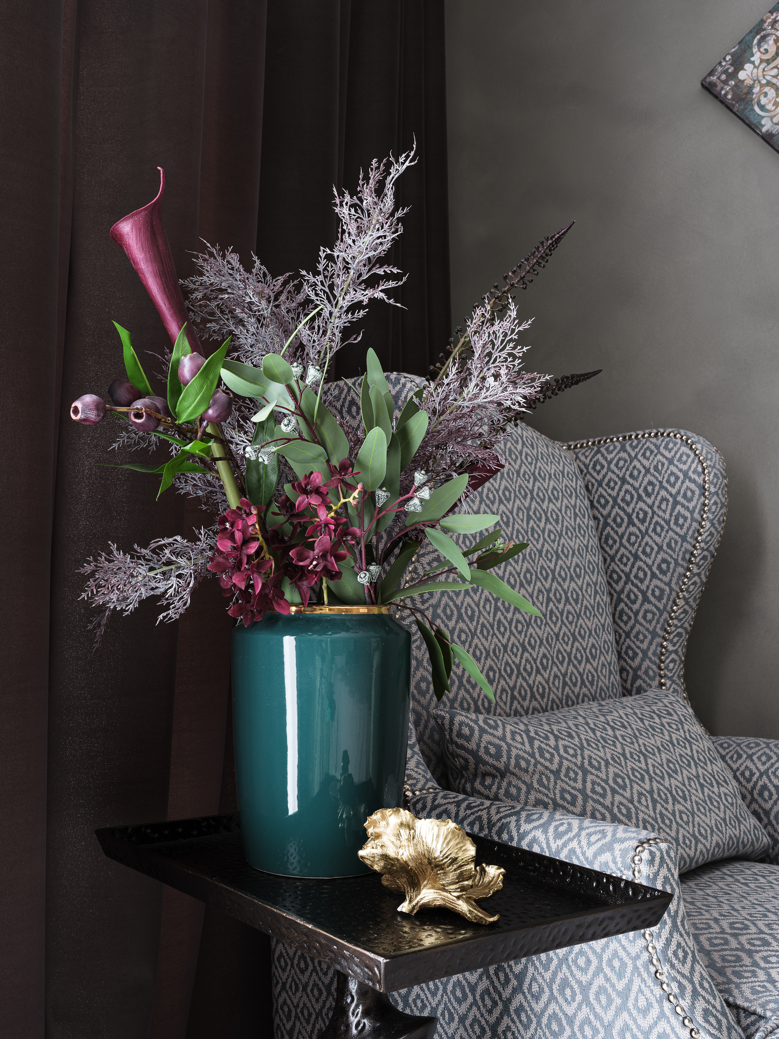 Декоративная композиция в изумрудной вазе на черном столике рядом с мягким креслом с геометрическим узором, акцентный бордовый декор и стильный текстиль. Автор интерьера Ирина Вольхина, стилист Марина Чернышева, фотограф Сергей Денисенко