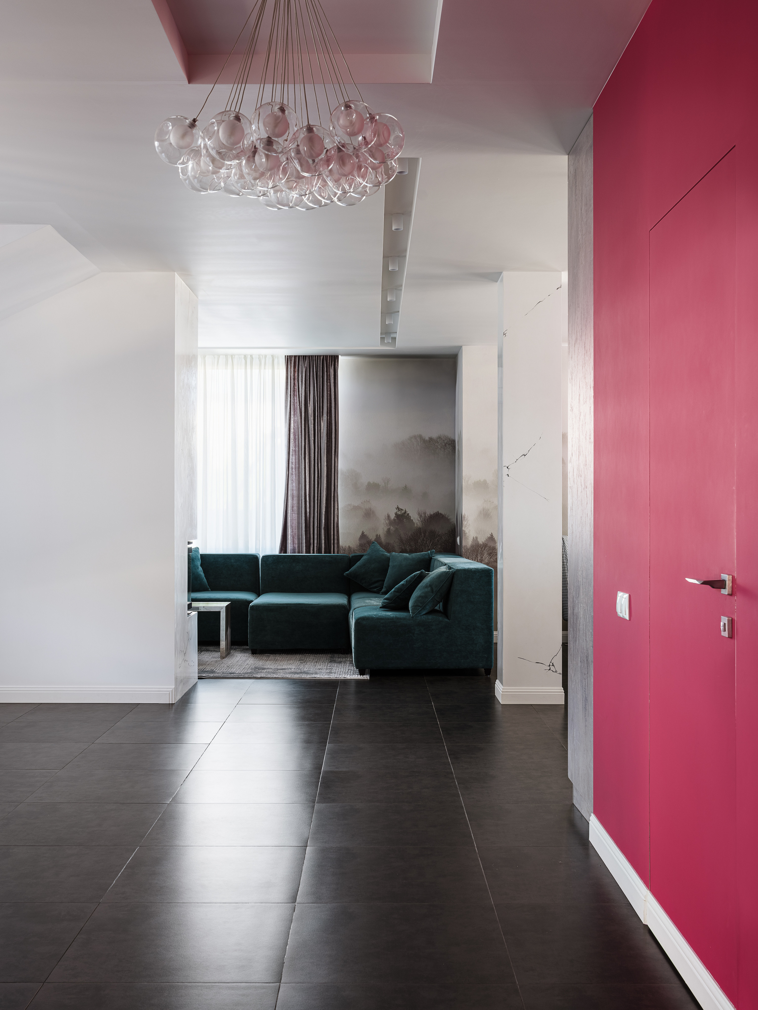 Интерьер прихожей с малиновой акцентной стеной, дизайнерской люстрой и видом на уютную гостиную с изумрудным диваном. Работа дизайнера Ирины Вольхиной, стилиста Марины Чернышевой, фото Сергея Денисенко.