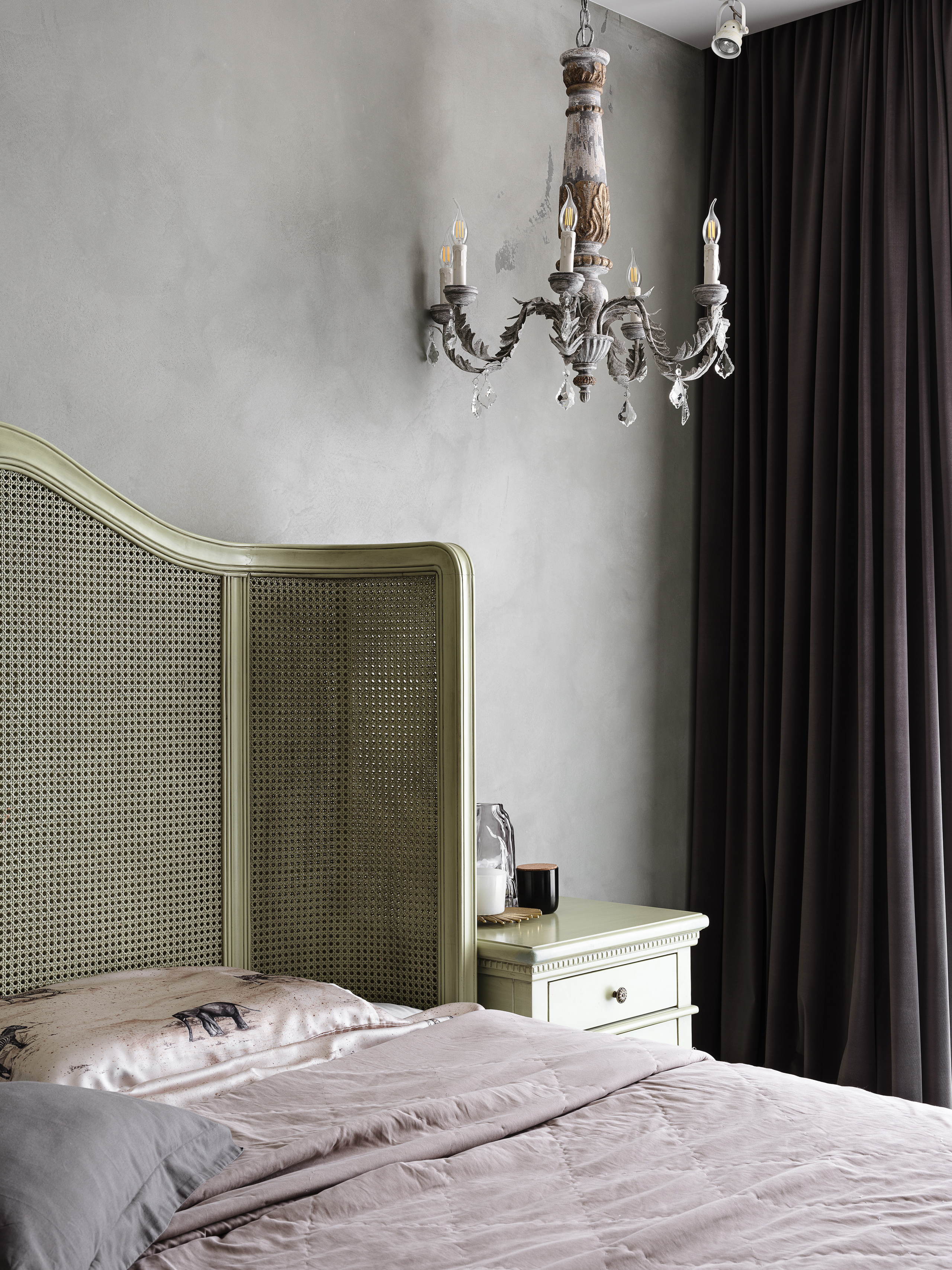 Спальня с изголовьем из плетеного дерева в оливковом цвете, старинная люстра с подсвечниками, прикроватная тумба и пастельное постельное белье. Дизайнер интерьера Ирина Вольхина, стилист Марина Чернышева, фотограф Сергей Денисенко
