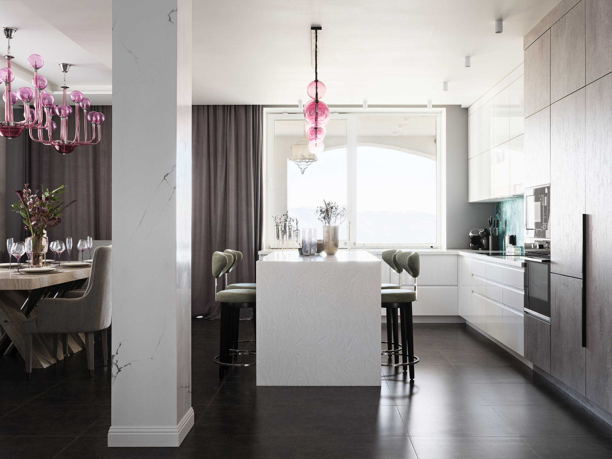 Общий вид на кухню с белыми фасадами и столовую с большим деревянным столом и розовой люстрой. Интерьер создан дизайнером Ириной Вольхиной, стилист Марина Чернышева, фотограф Сергей Денисенко.
