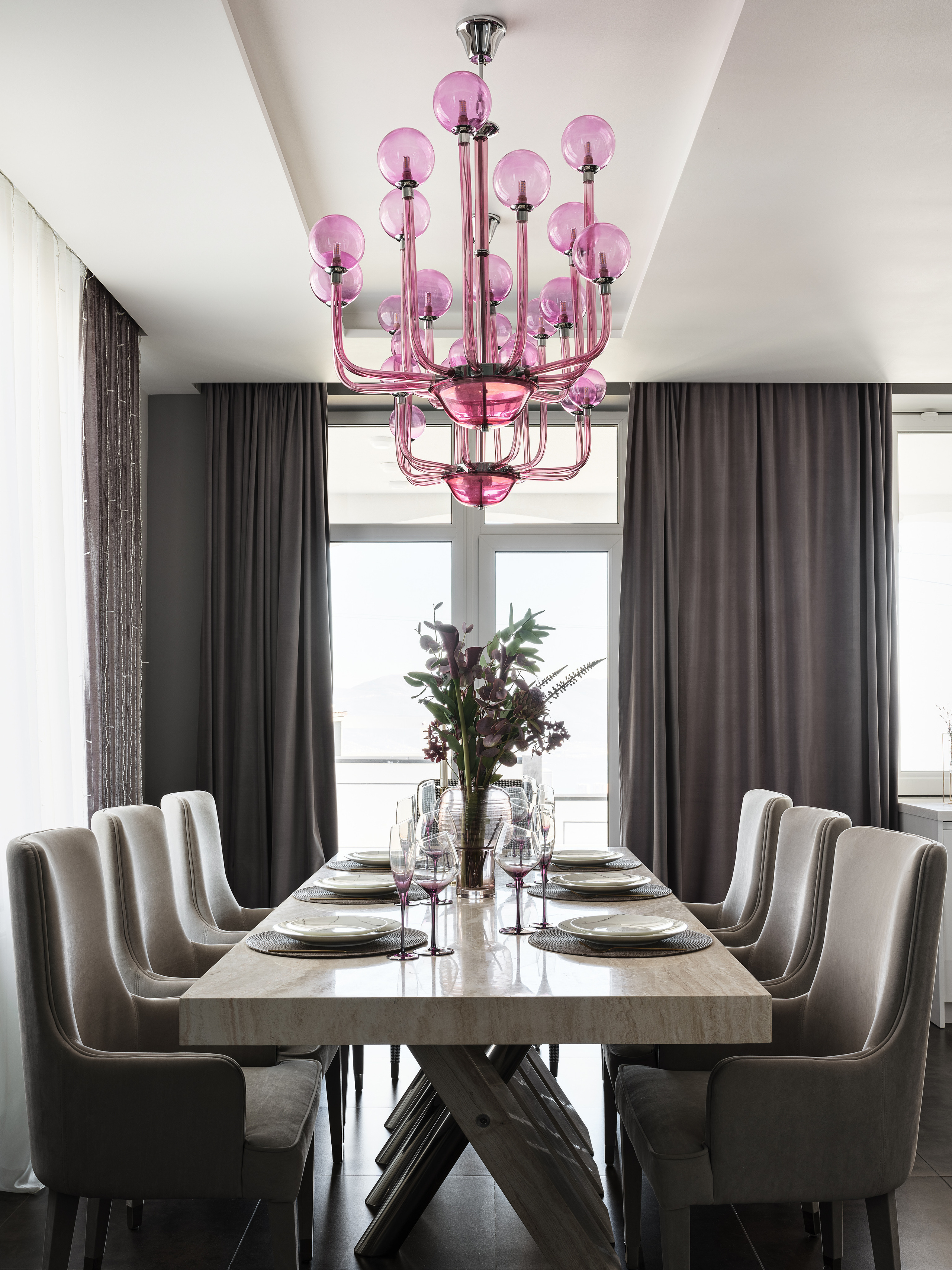 Элегантная столовая с массивным мраморным столом, мягкими креслами и акцентной люстрой из розового стекла. Интерьер разработан дизайнером Ириной Вольхиной, стилист Марина Чернышева, фото Сергей Денисенко.