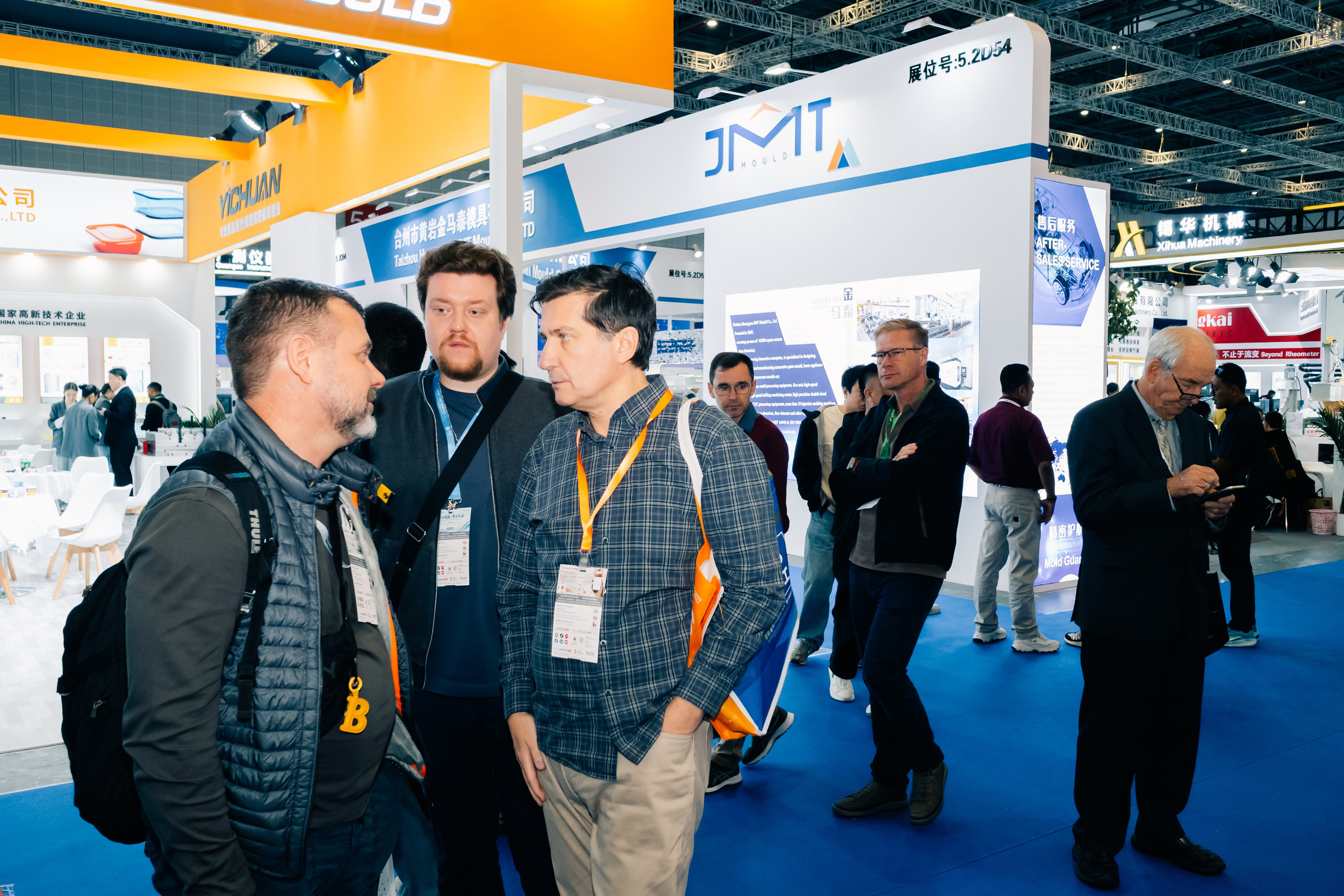 Участники выставки CHINAPLAS общаются у стенда в Шанхае, VZLP, деловая атмосфера, фото и видеосъемка.