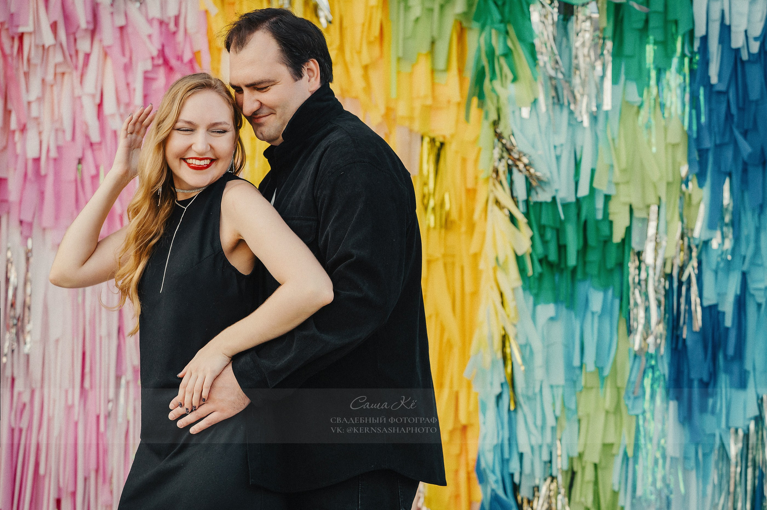 Жених поднимает невесту на руках на фоне города