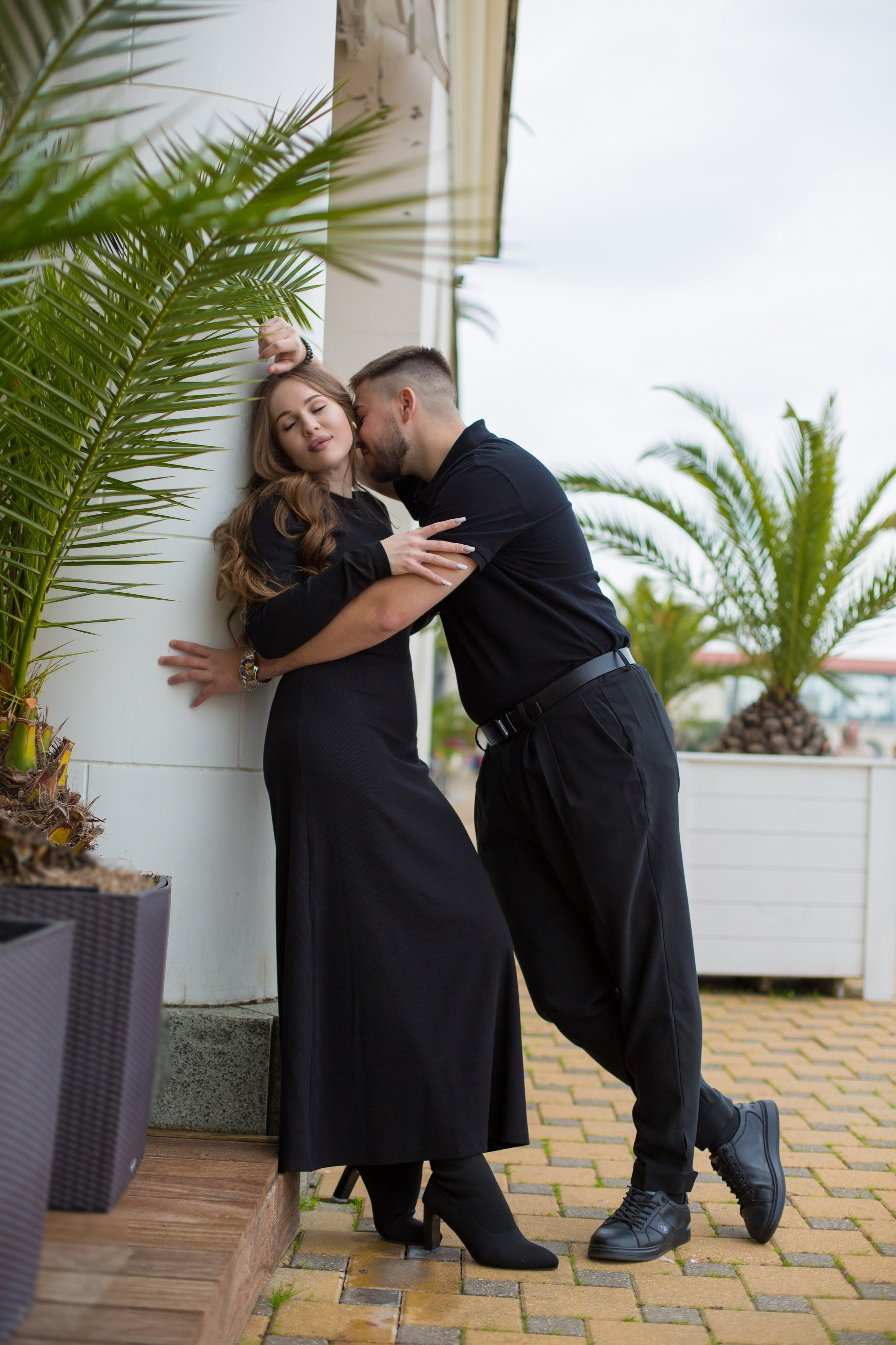 парень и девушка стоят возле колонны и обнимаются