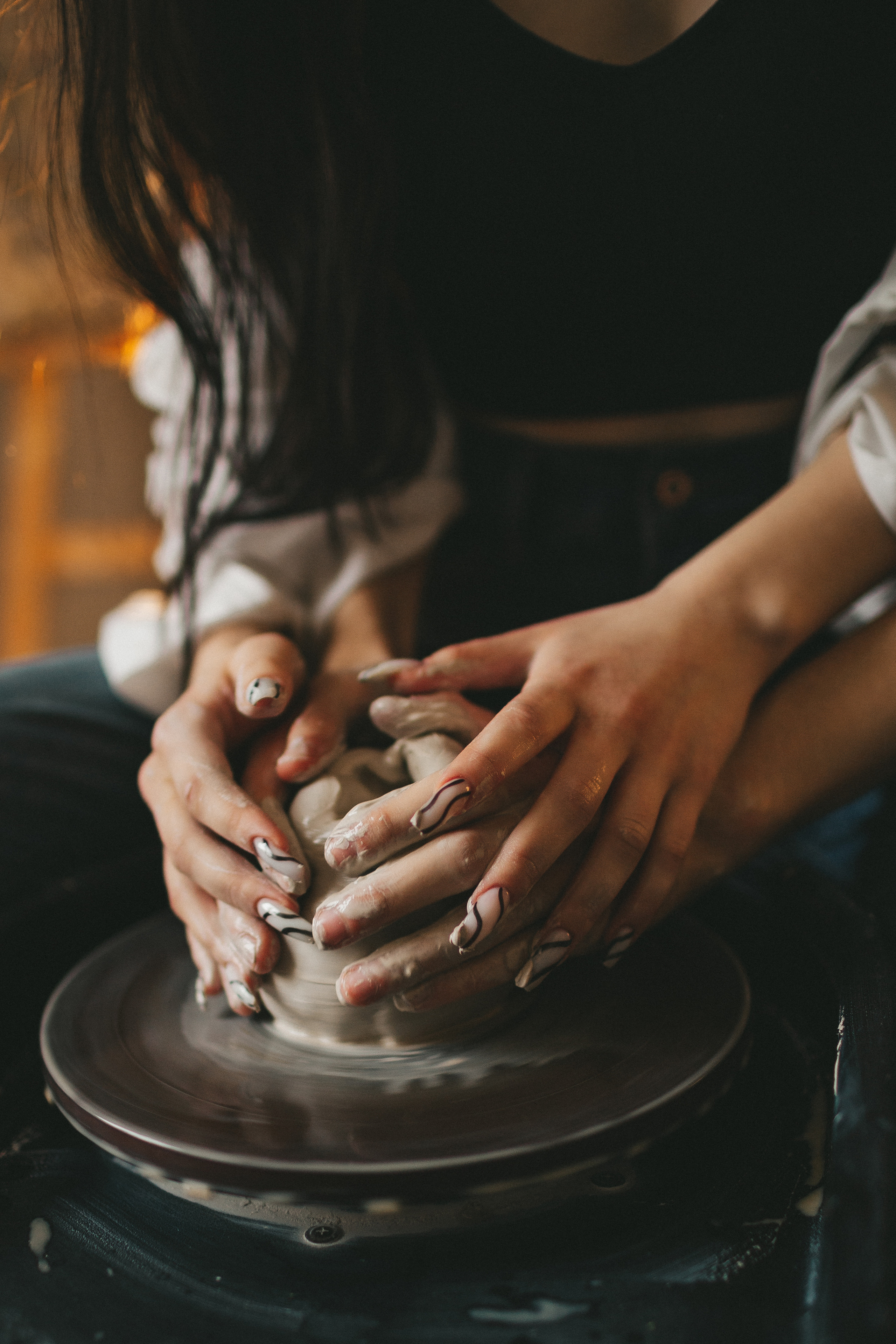 руки на гончарном круге с глиной