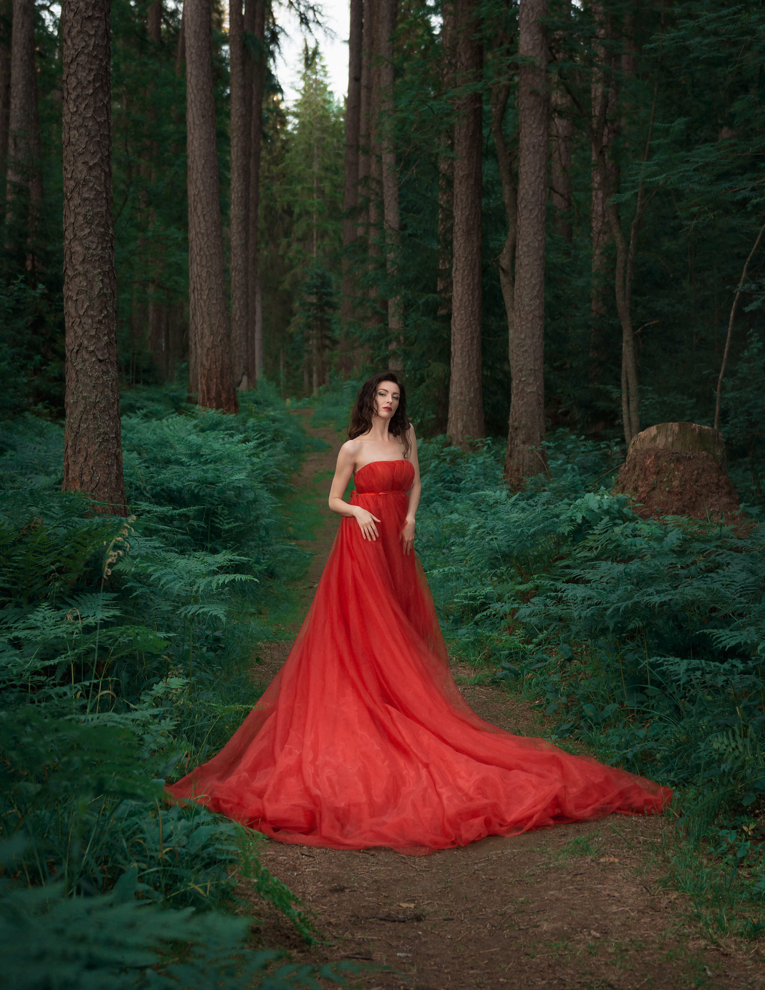 Девушка в красном платьев лесу