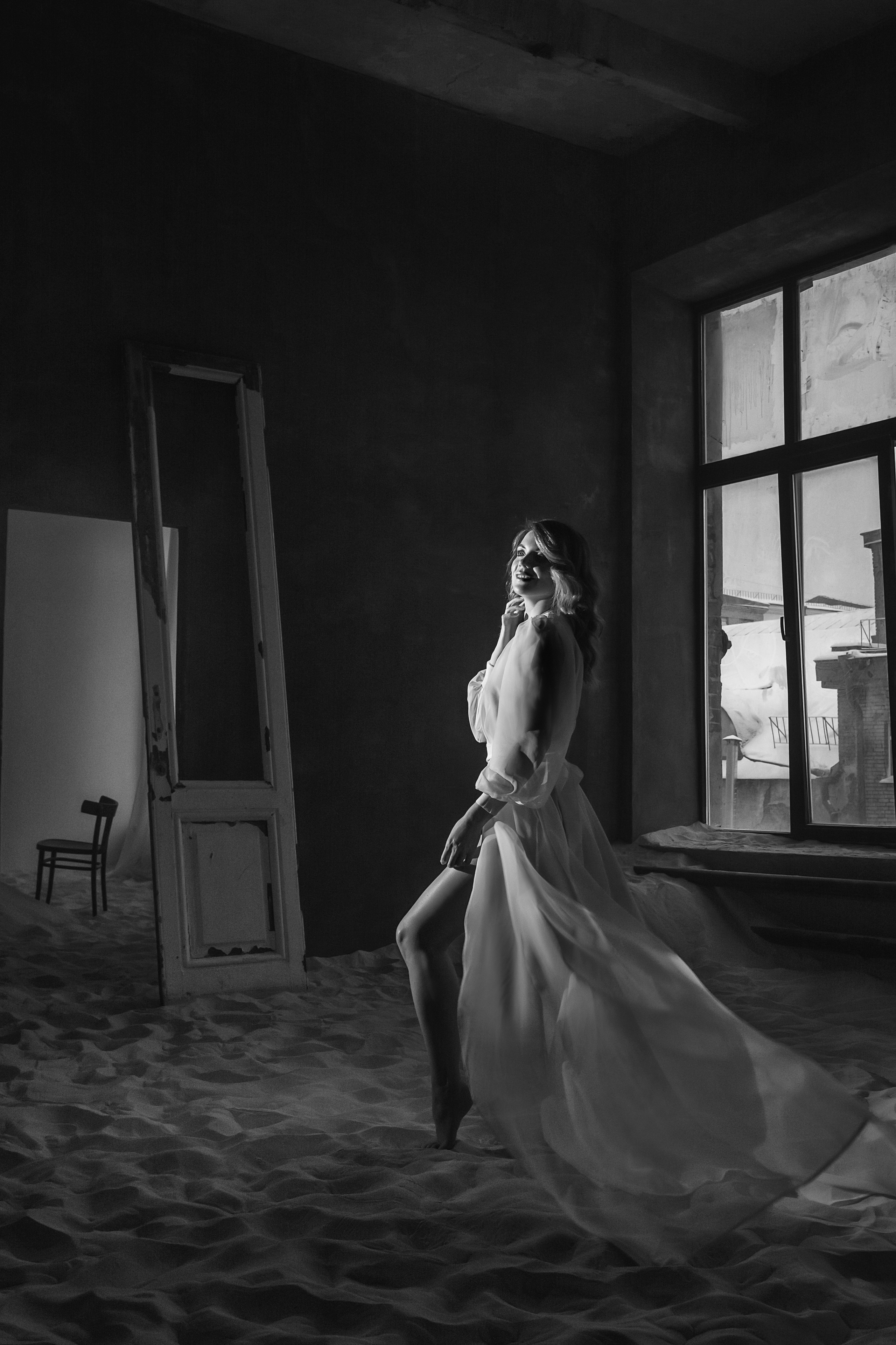 Девушка в белом халатике окна лофт песок чб