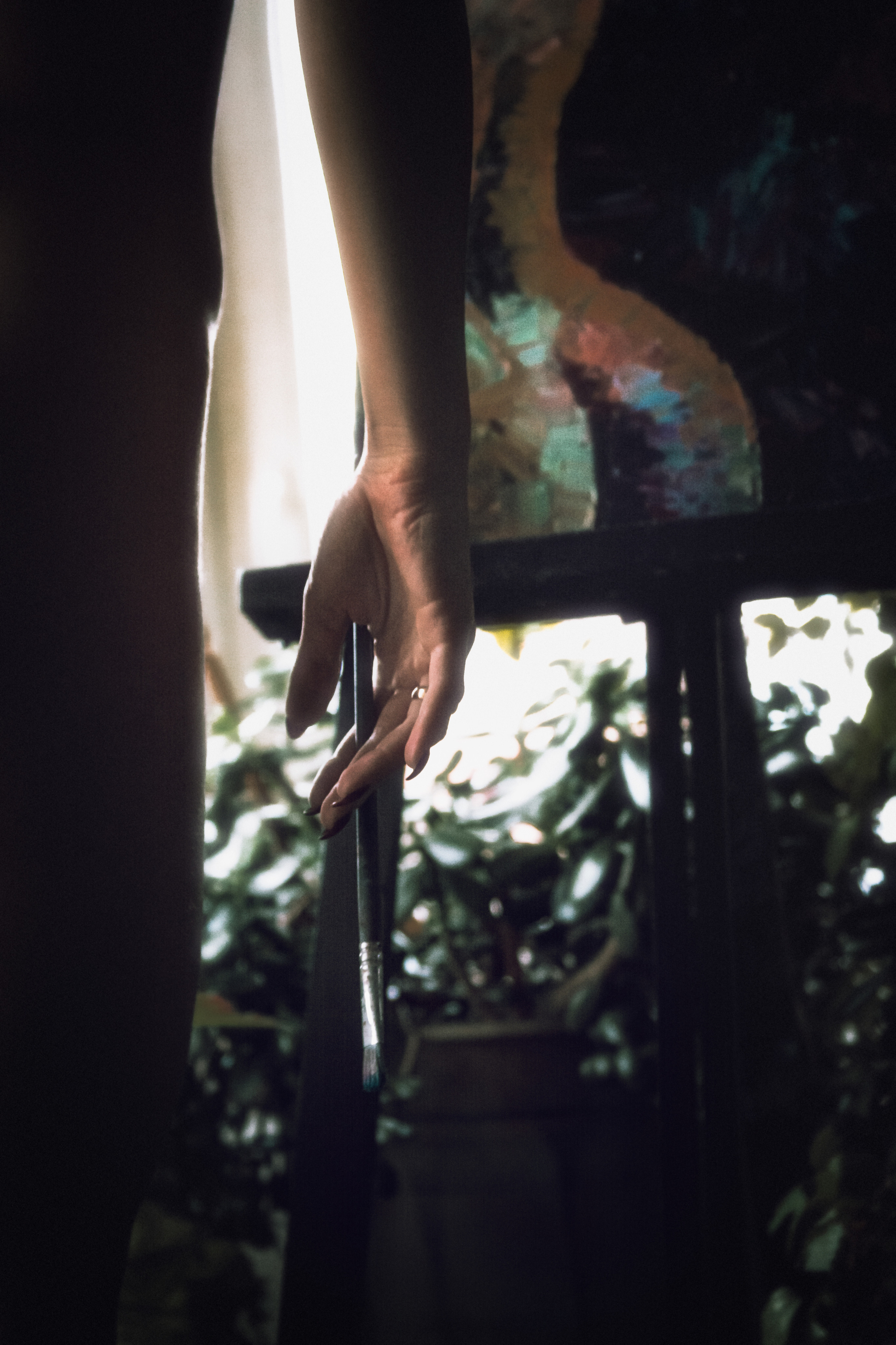 Рука с кистью перед картиной