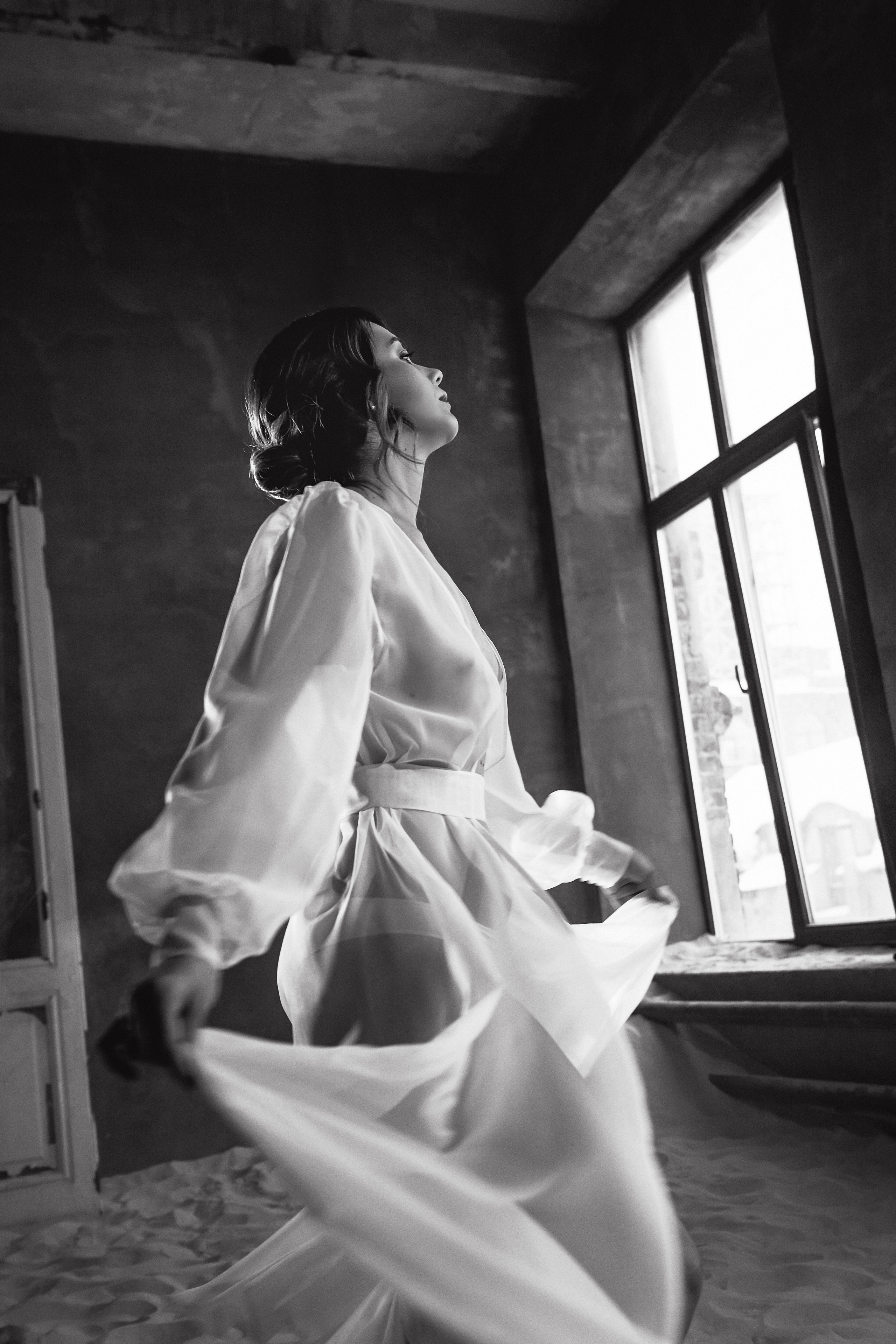 Девушка в белом халатике окна лофт песок чб