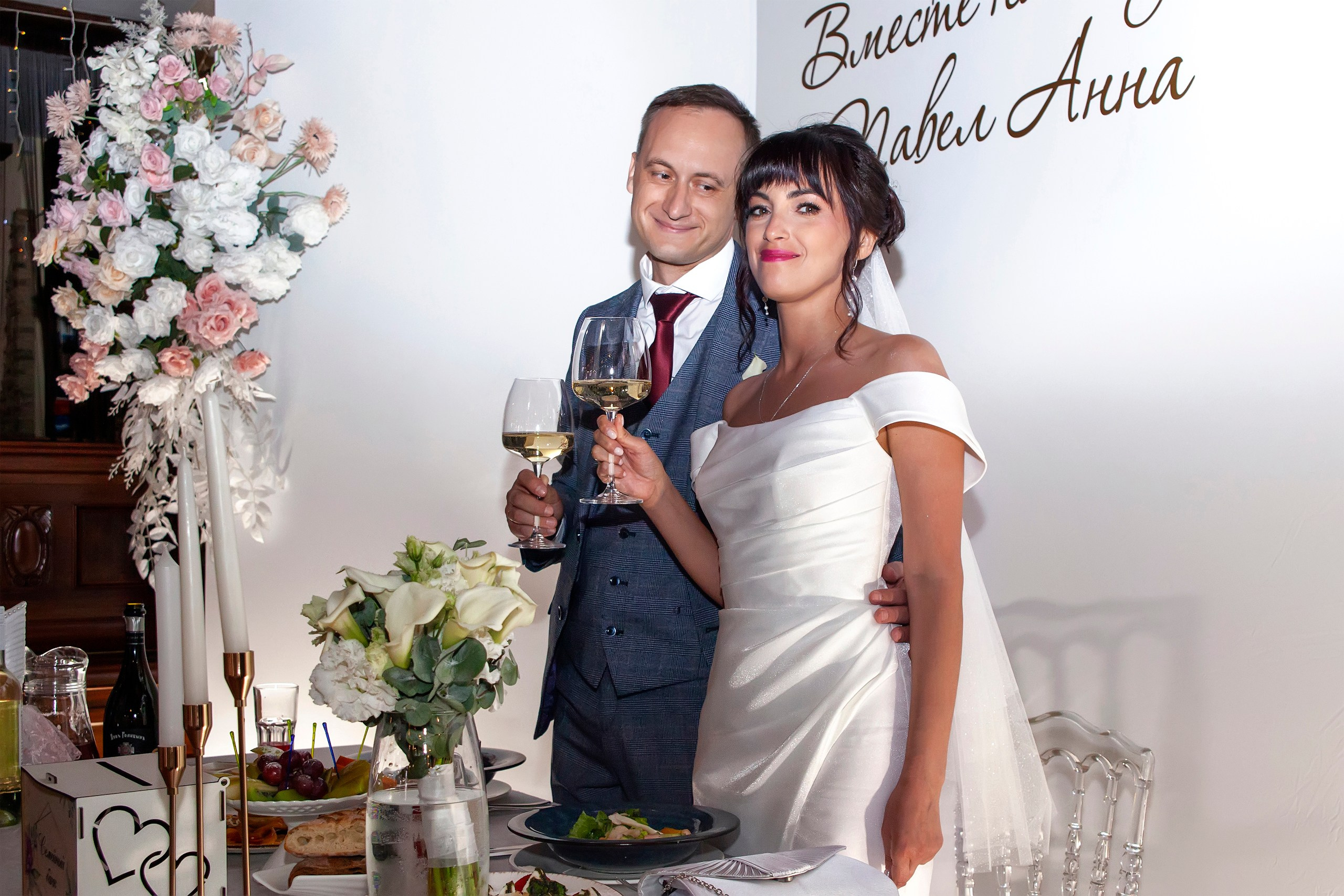 Молодые на фоне свадебного баннера в ресторане