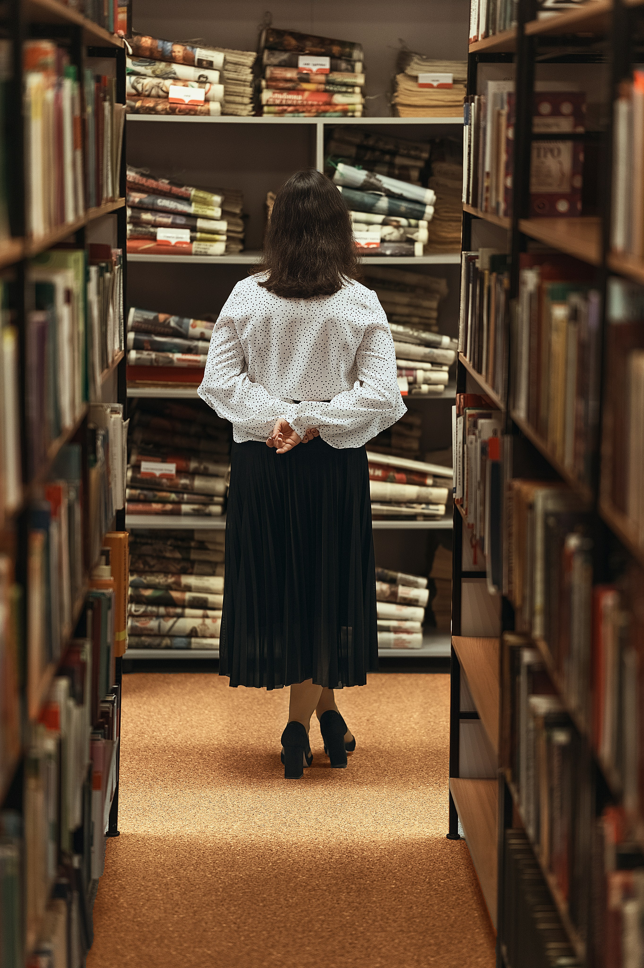 Елизавета Жуйкова, Волгодонск: съёмка в библиотеке. Модель в светлой блузке и тёмной юбке среди книжных стеллажей — атмосферные кадры с книгами
