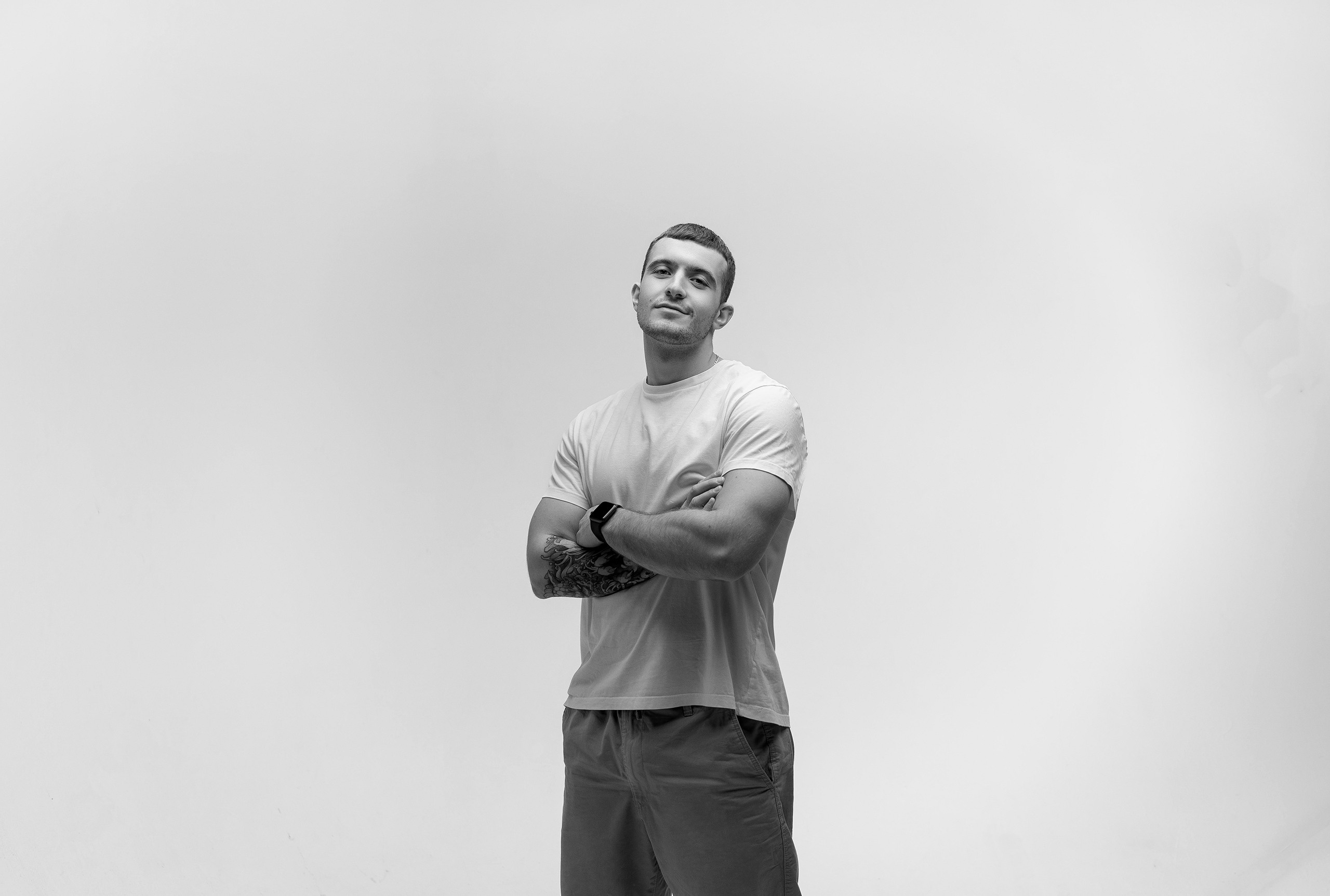 Парень сложил руки на груди на белом фоне