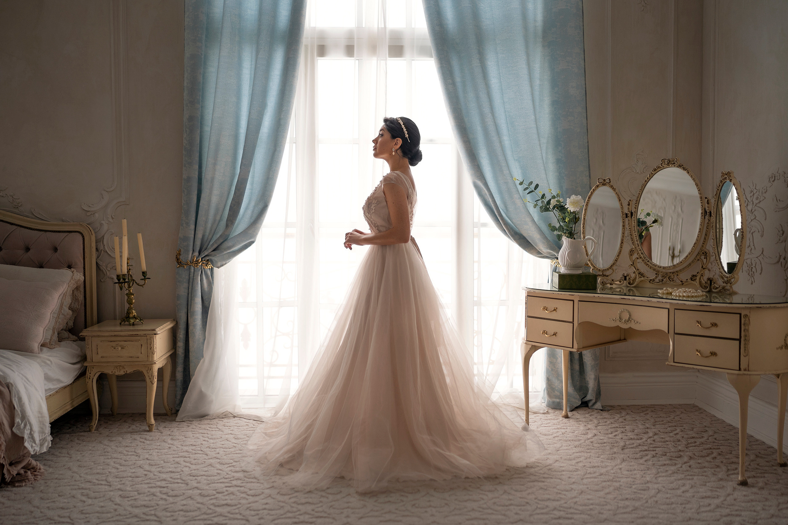 Девушка в свадебном платье у окна