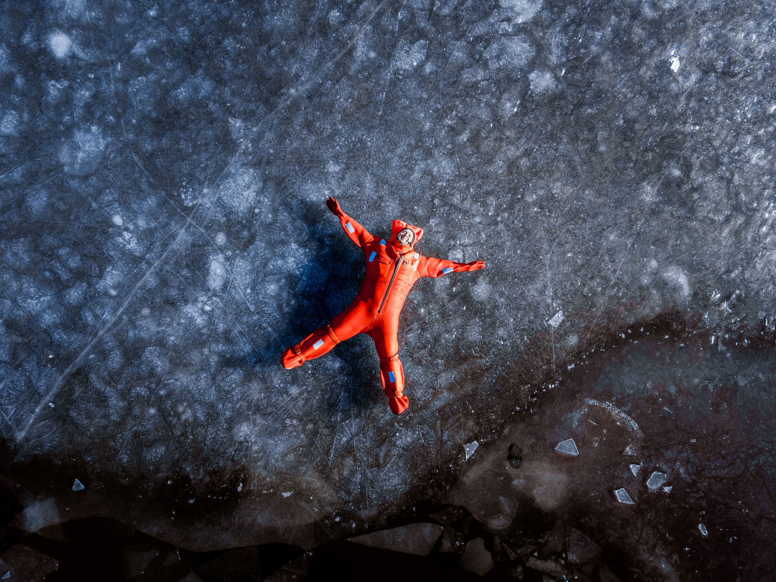 Люди купаются среди льдин, в спасательных оранжевых термо костюмах, айс флоатинг Ярославль