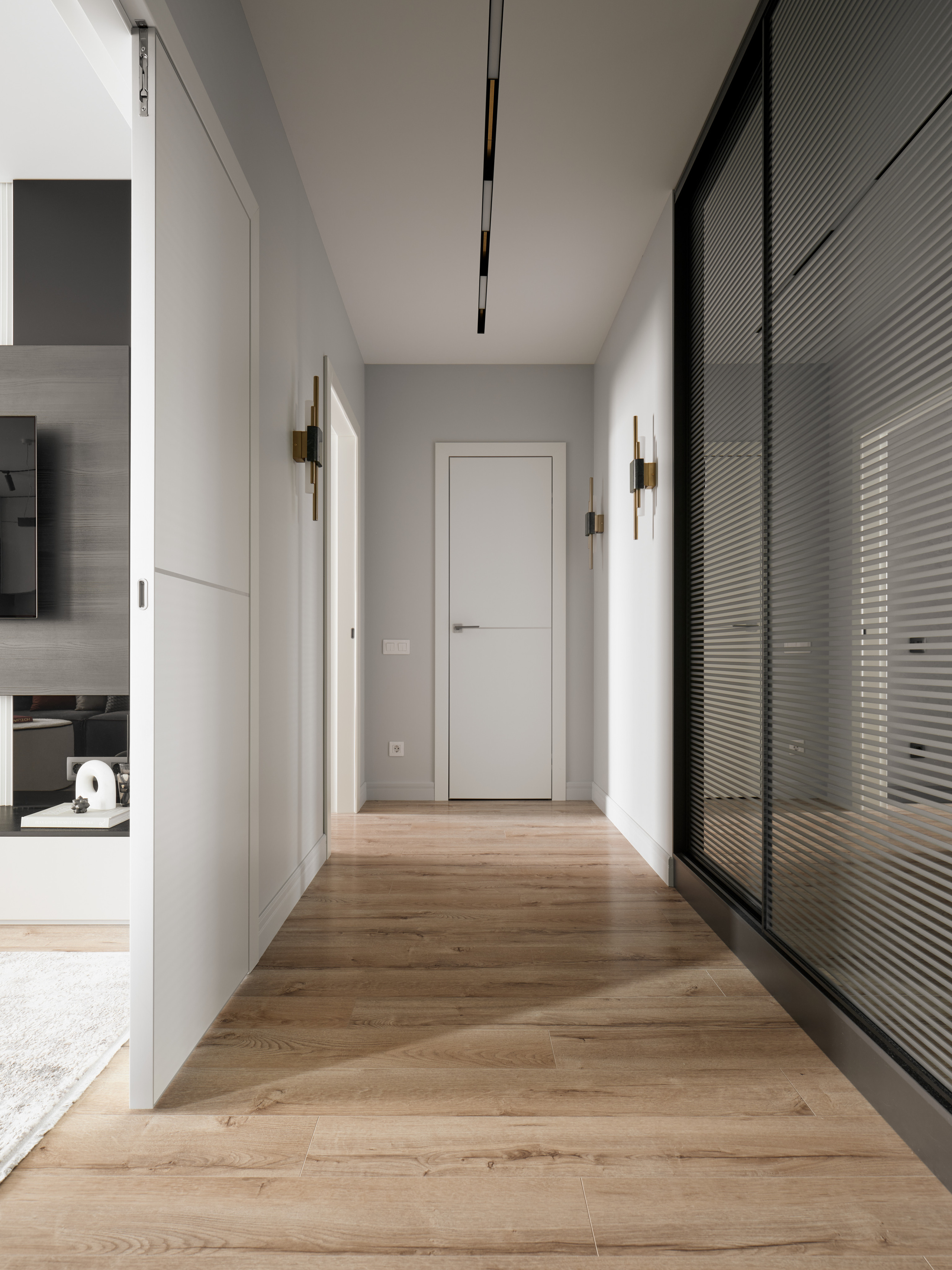 Светлый современный коридор с паркетным полом, белыми дверями и встроенной подсветкой, дизайнер Екатерина Мищенко, фотограф Сергей Денисенко, интерьер в стиле минимализм с акцентом на геометрию и световые линии.