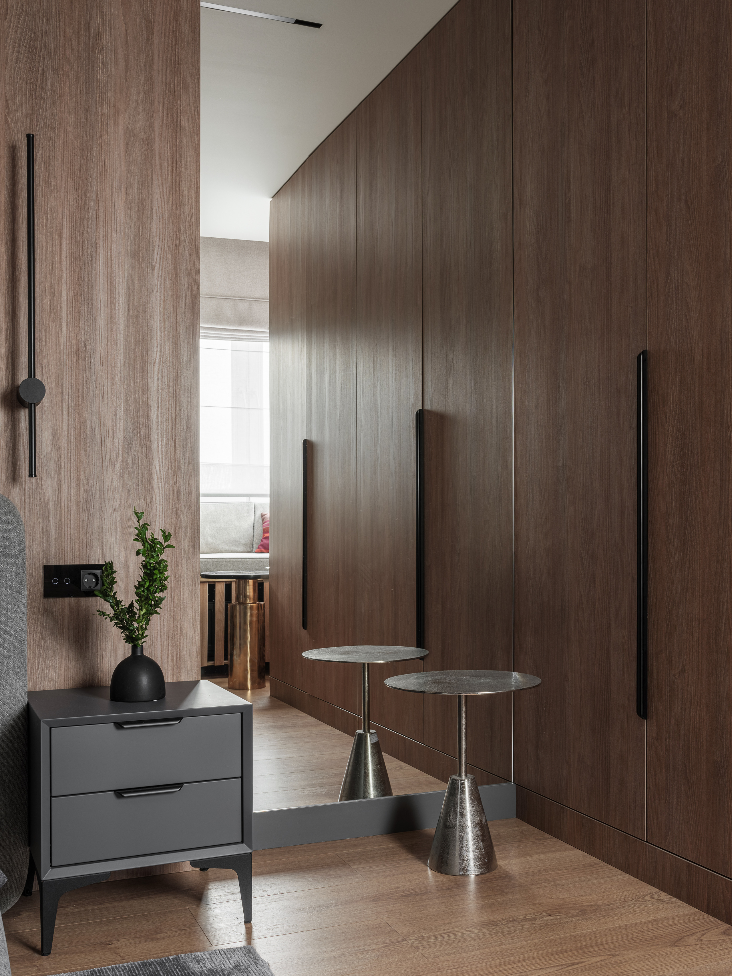 Современная спальня с серой прикроватной тумбой, металлическим столиком и встроенными деревянными шкафами. Интерьер создан дизайнером Алёной Сверловой, фото Сергея Денисенко.