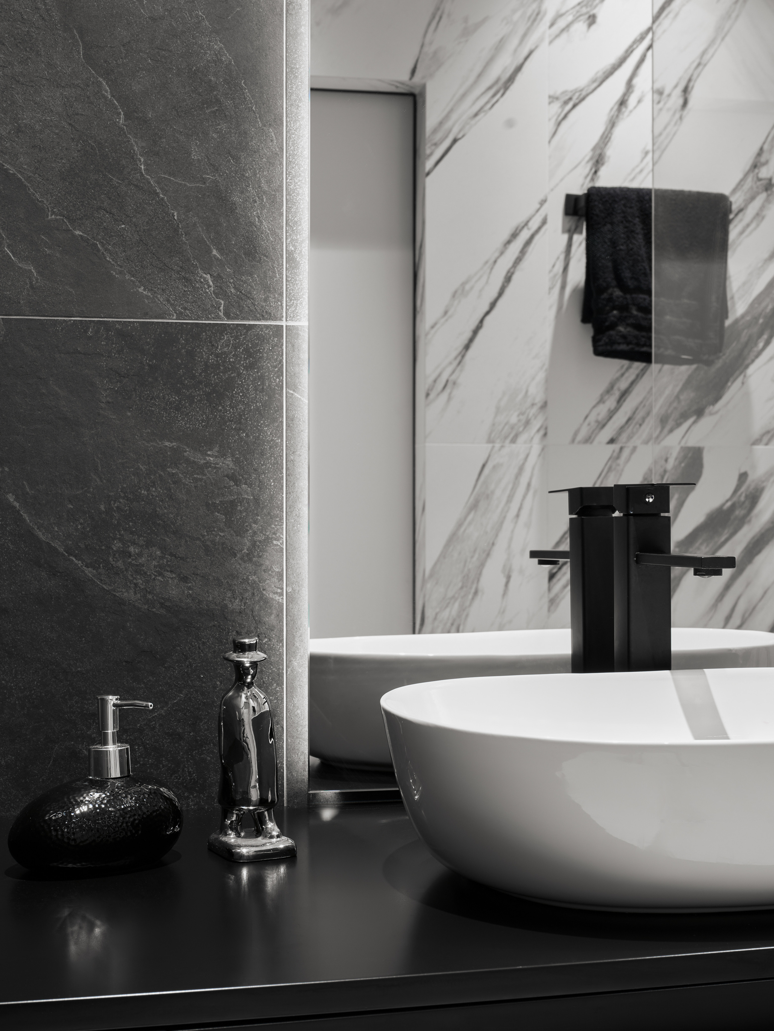 Деталь ванной комнаты — черная матовая столешница с белой накладной раковиной и аксессуарами в стиле минимализм, акцент на фактуру камня и мраморные стены, дизайн Андрея Нелень и Екатерины Проскуряковой, стилист Алина Нелень, фотограф Сергей Денисенко.