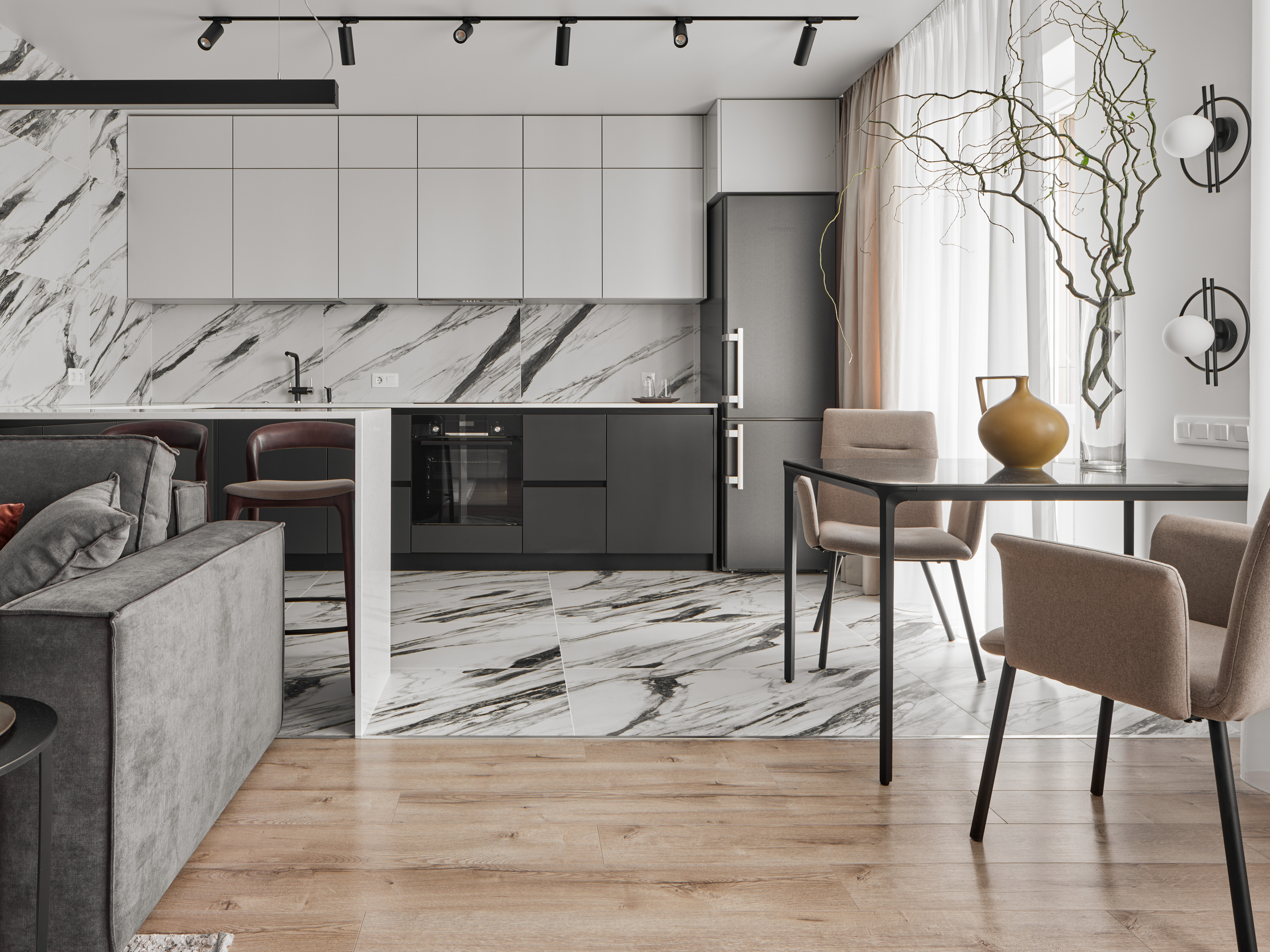 Интерьер кухни-столовой с белыми и черными фасадами, мраморным фартуком и обеденной зоной у окна. Современный минимализм от дизайнера Екатерины Мищенко, фото Сергея Денисенко.