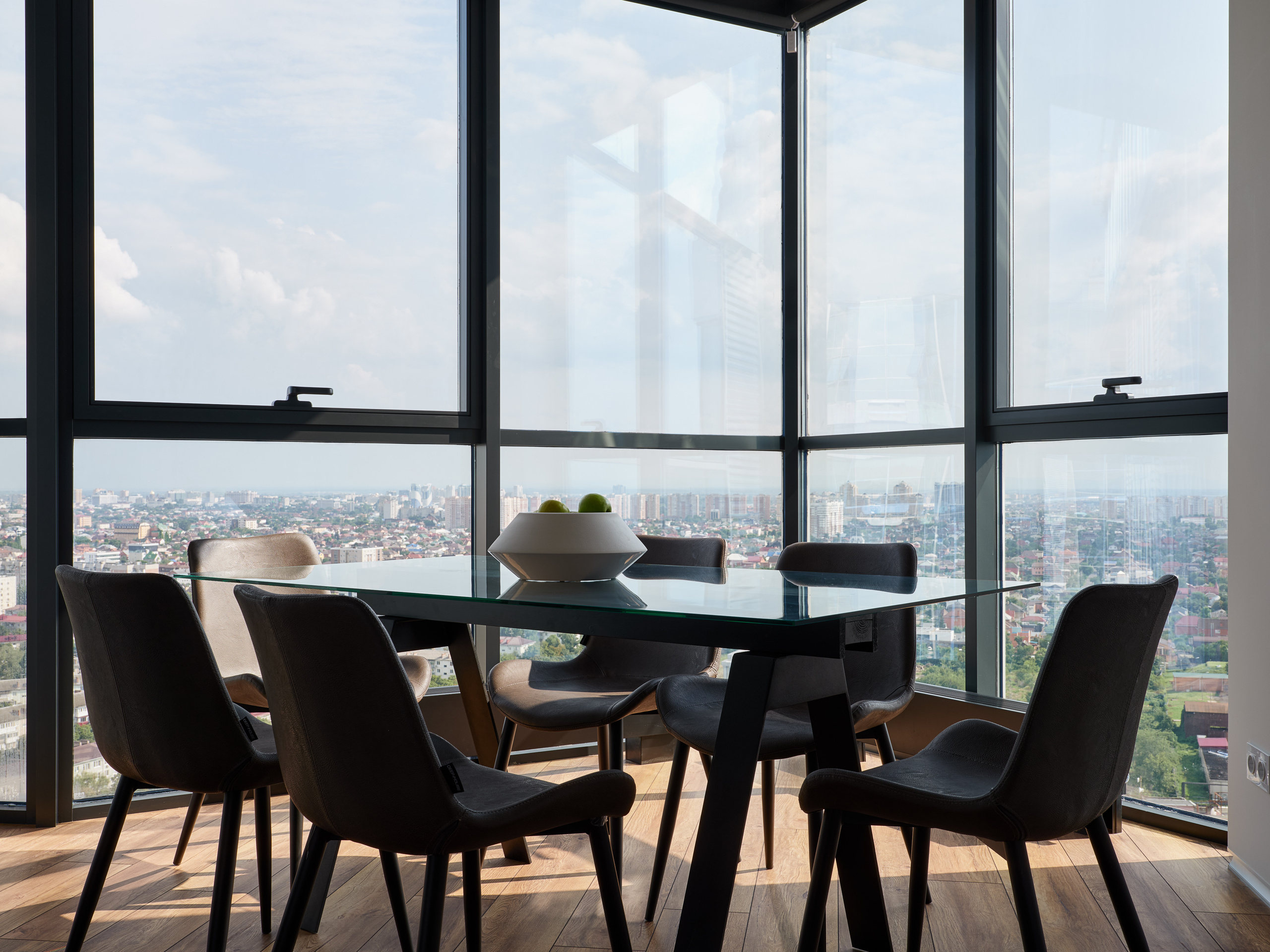 Просторная столовая с панорамным остеклением и видом на город, стеклянным обеденным столом и современными стульями, интерьер от Андрея Неленя и Екатерины Проскуряковой, стилистика Алины Нелень, фото Сергея Денисенко.