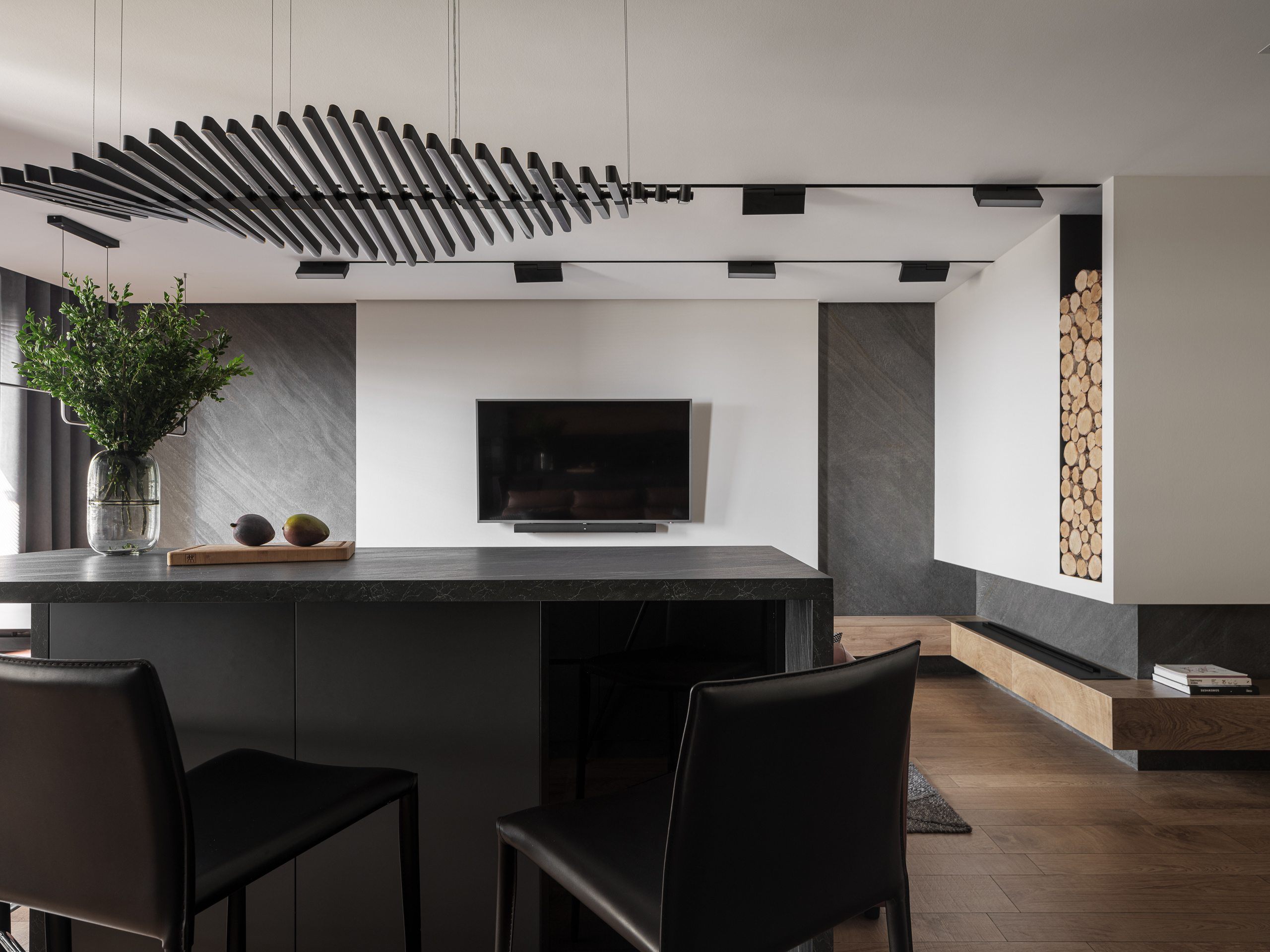 Современная кухня-гостиная с каменной барной стойкой, встроенным телевизором и декоративной нишей с дровами, гармония минимализма и уюта, проект дизайнера Алёны Сверловой, фотосъёмка Сергей Денисенко.