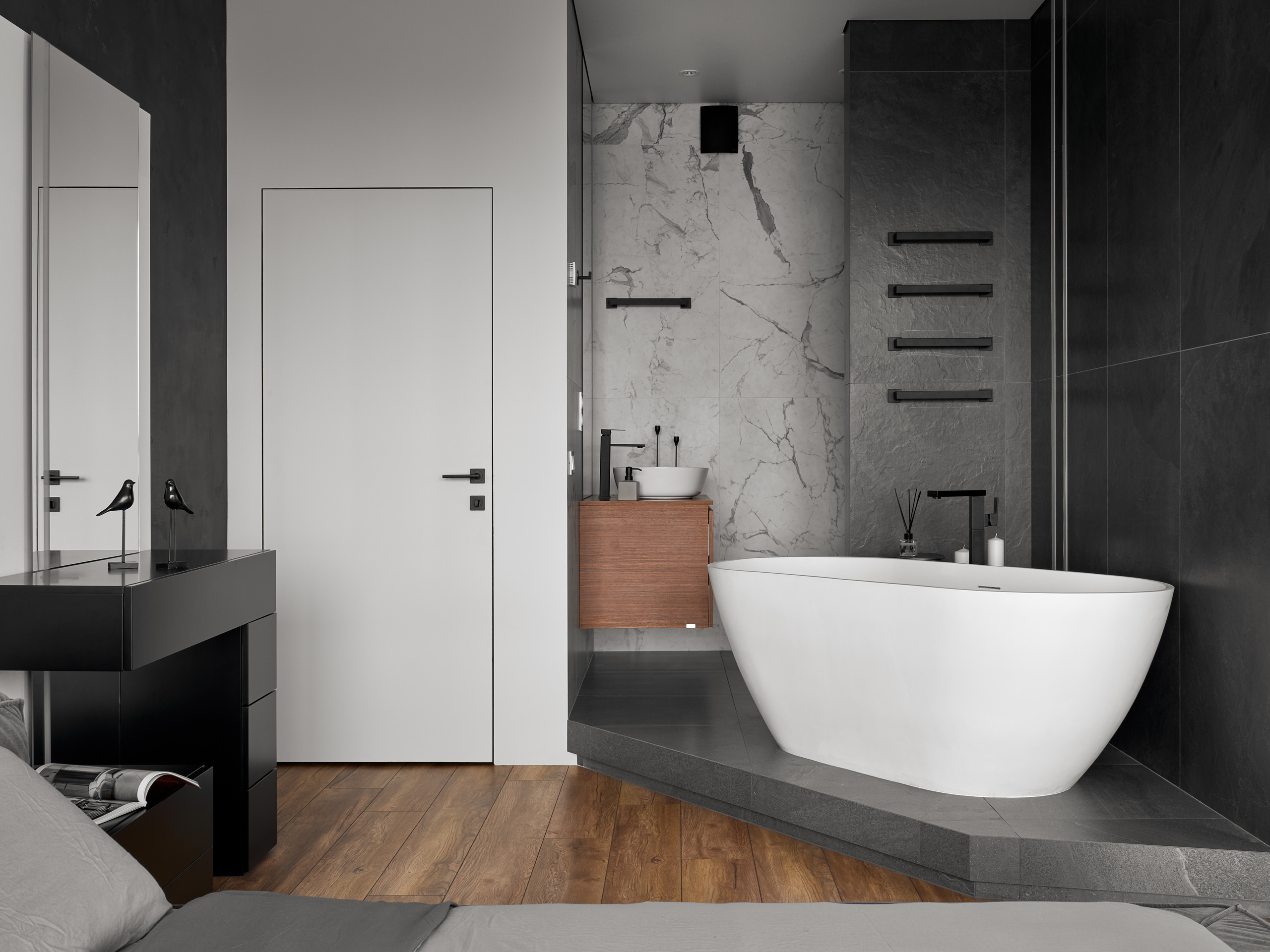 Спальня с интегрированной ванной зоной, где белая отдельностоящая ванна подчеркнута мраморной плиткой и темными поверхностями, интерьер дизайнеров Андрея Нелень и Екатерины Проскуряковой, стилист Алина Нелень, фотограф Сергей Денисенко.
