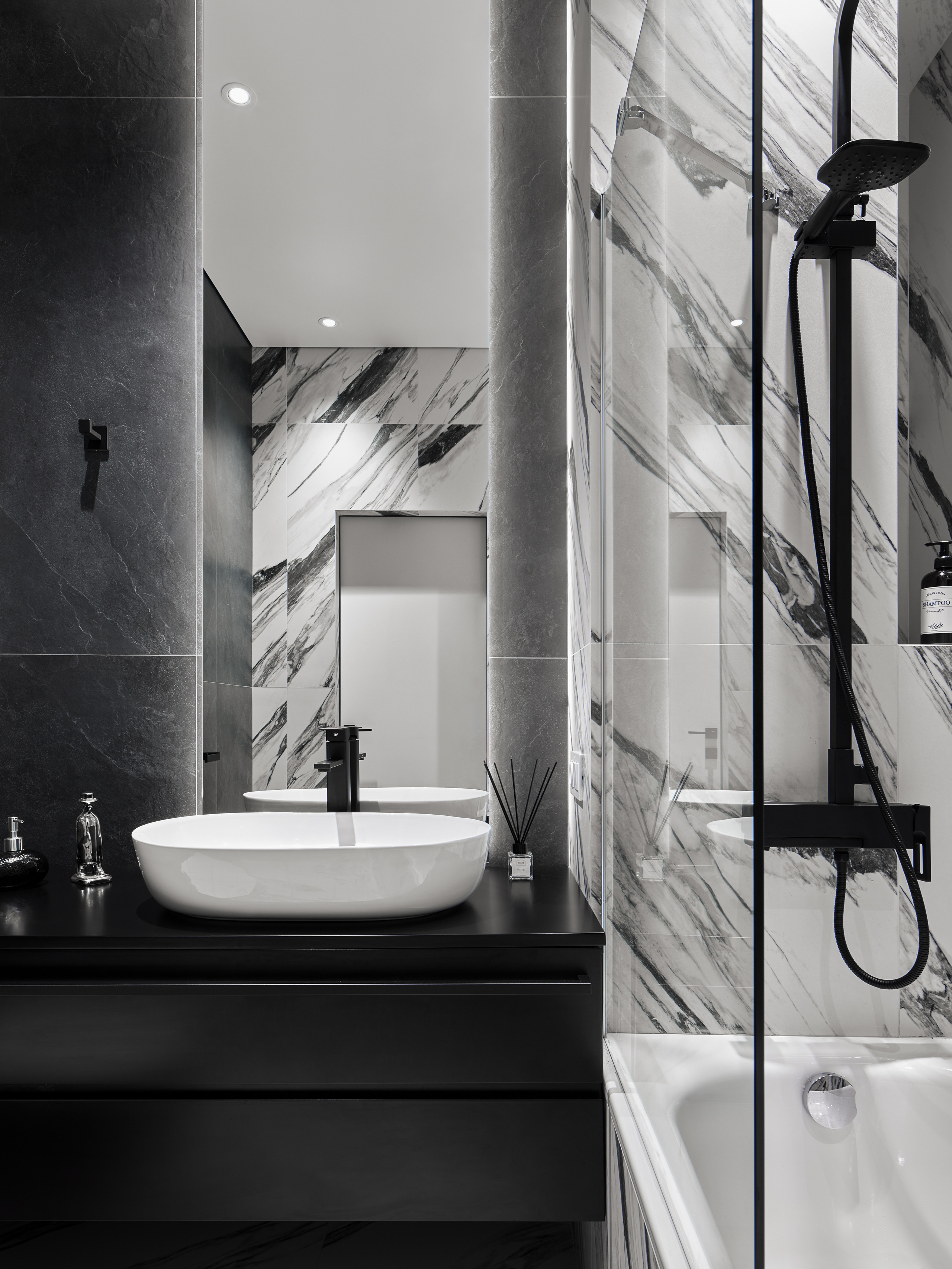Интерьер ванной с ванной-купелью, мраморной плиткой и черными смесителями, гармоничное сочетание серых фактур и белых акцентов, проект дизайнеров Андрея Нелень и Екатерины Проскуряковой, стилизация Алины Нелень, фотография Сергея Денисенко.