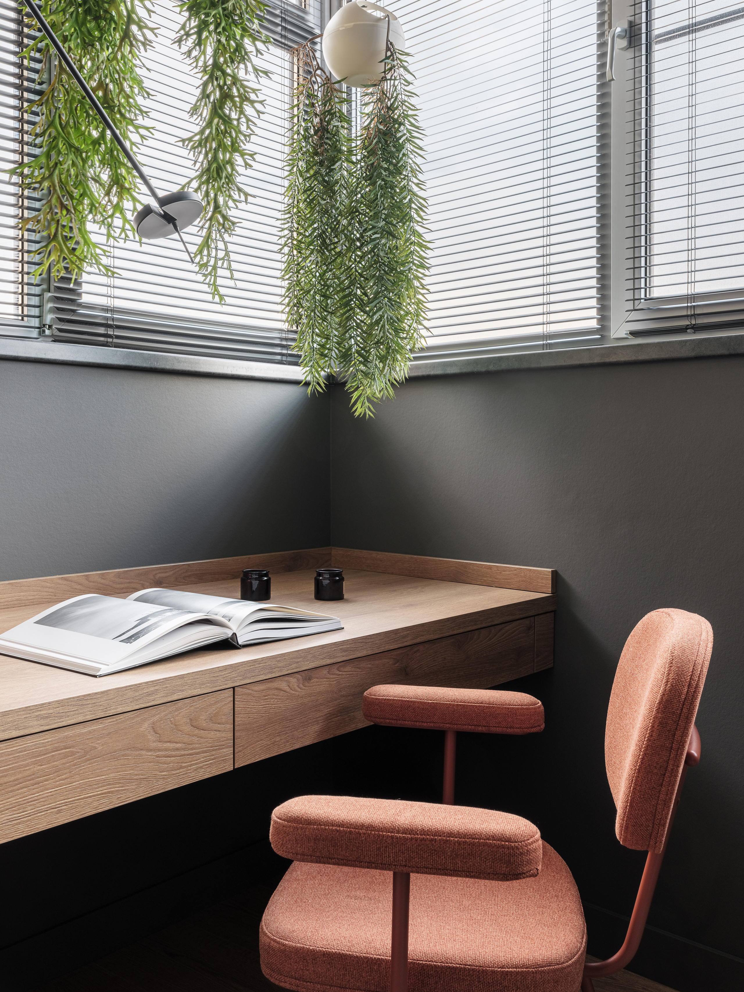 Минималистичное рабочее место у окна с деревянной столешницей, стулом терракотового цвета и подвесными зелёными растениями. Дизайнер Алёна Сверлова, фотограф Сергей Денисенко, современный интерьер.