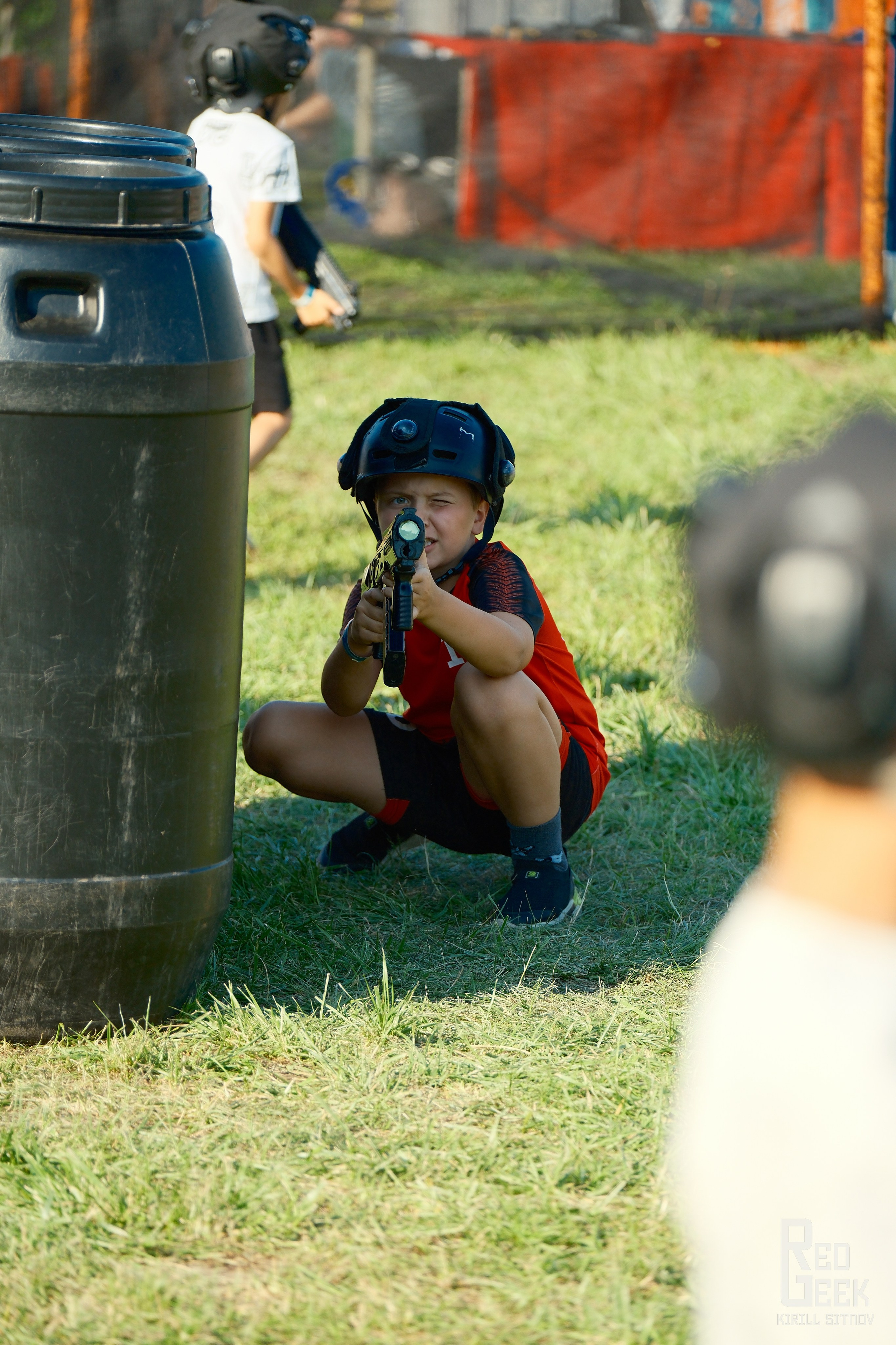 Мальчик целится в противника во время уличной игры в лазертаг на фестивале DDX Fitness 2025.