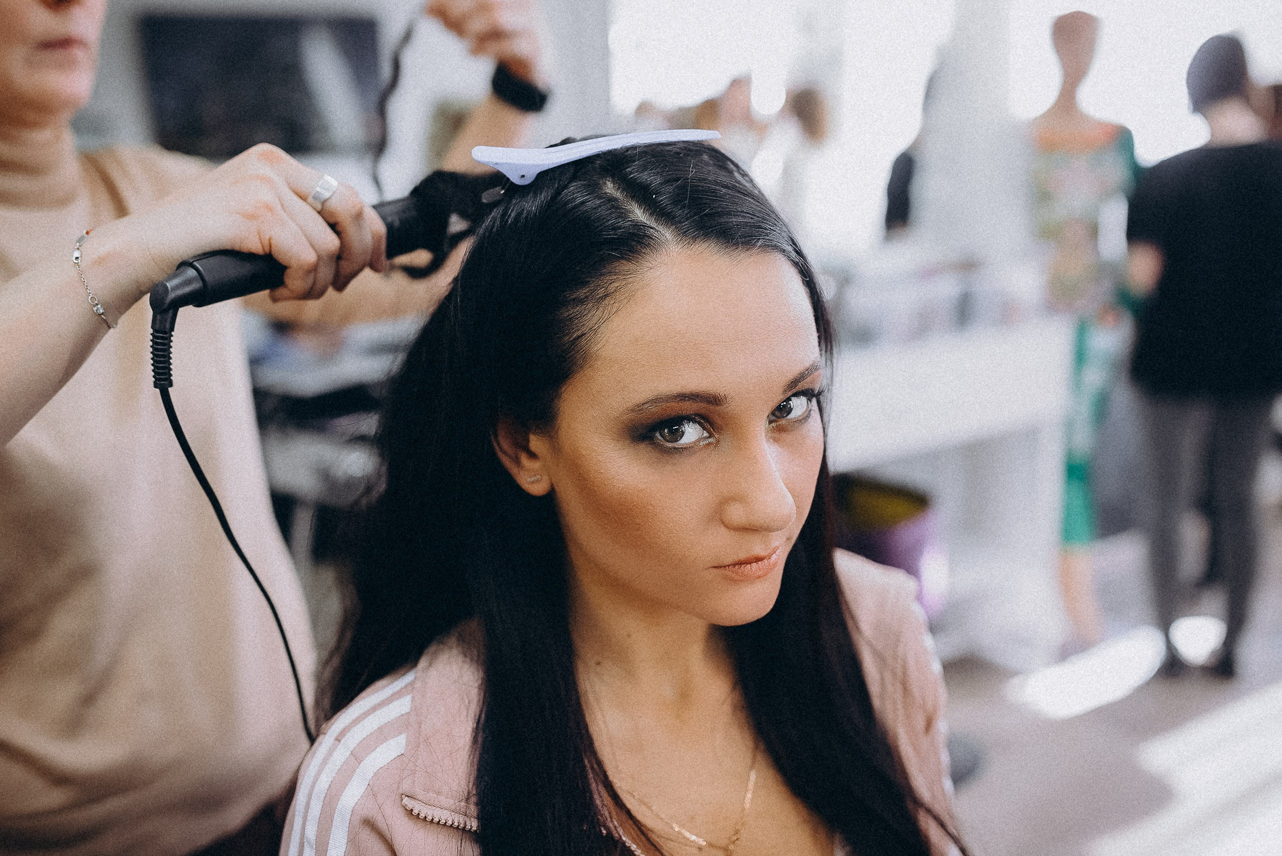 Финальная фиксация образа: использование стайлинговых средств для прически участницы.