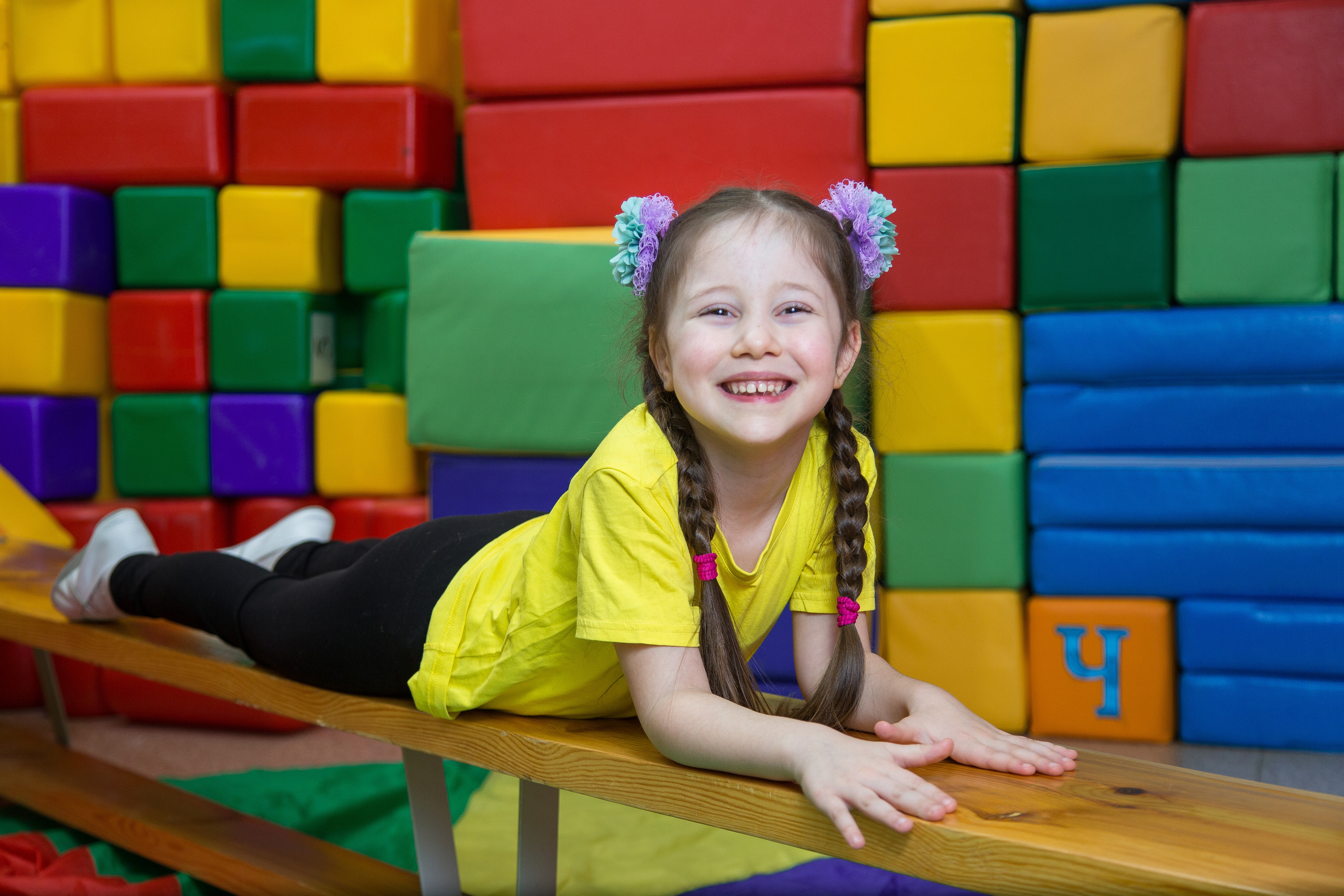 девочка ползет по лавочке на уроке физкультуры