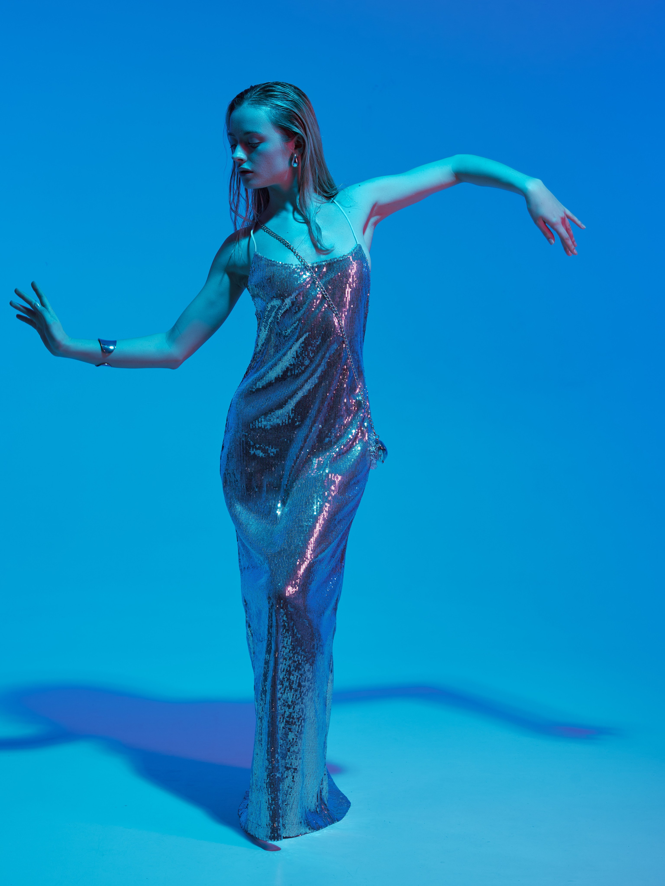 Творческая фэшн-съёмка с цветным синим светом на белой циклораме