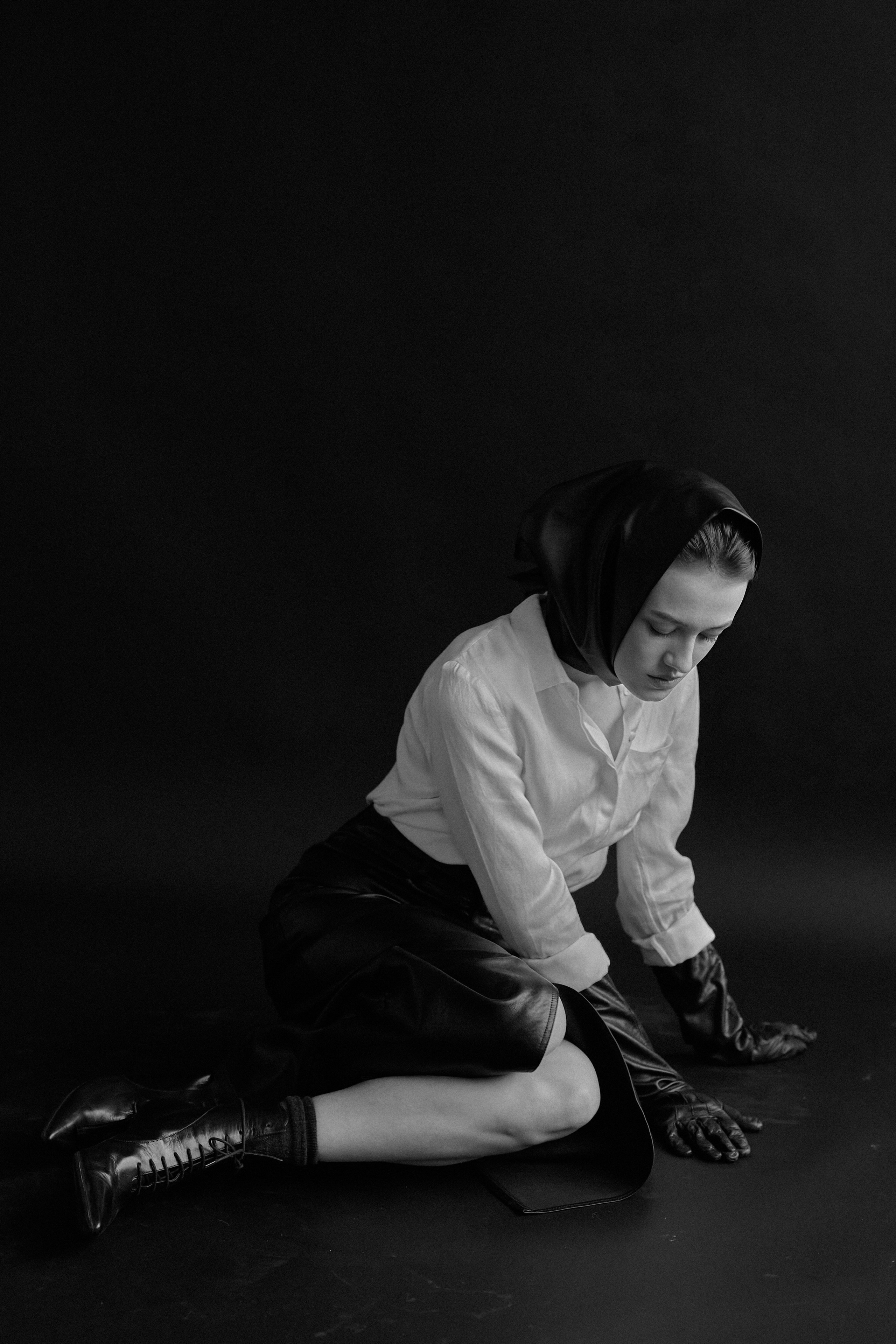 Фотограф в Москве. Студия. Студийный портрет. Девушка в черных кожаных перчатках и строгом костюме на черном фоне. Женский портрет. Воркшоп. Черно-белое фото.