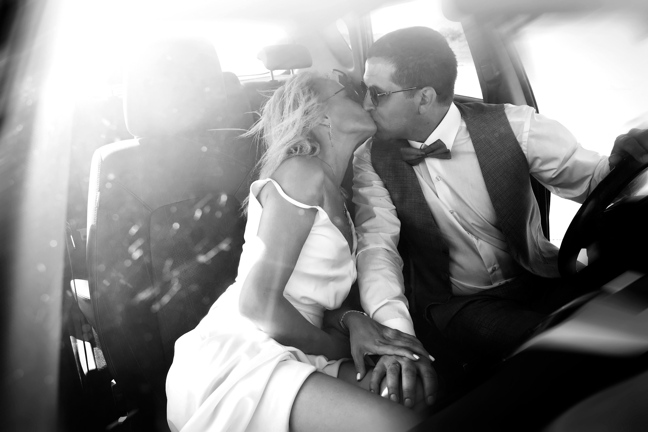 Черно белый портрет жениха и невесты в машине на передних сиденьях