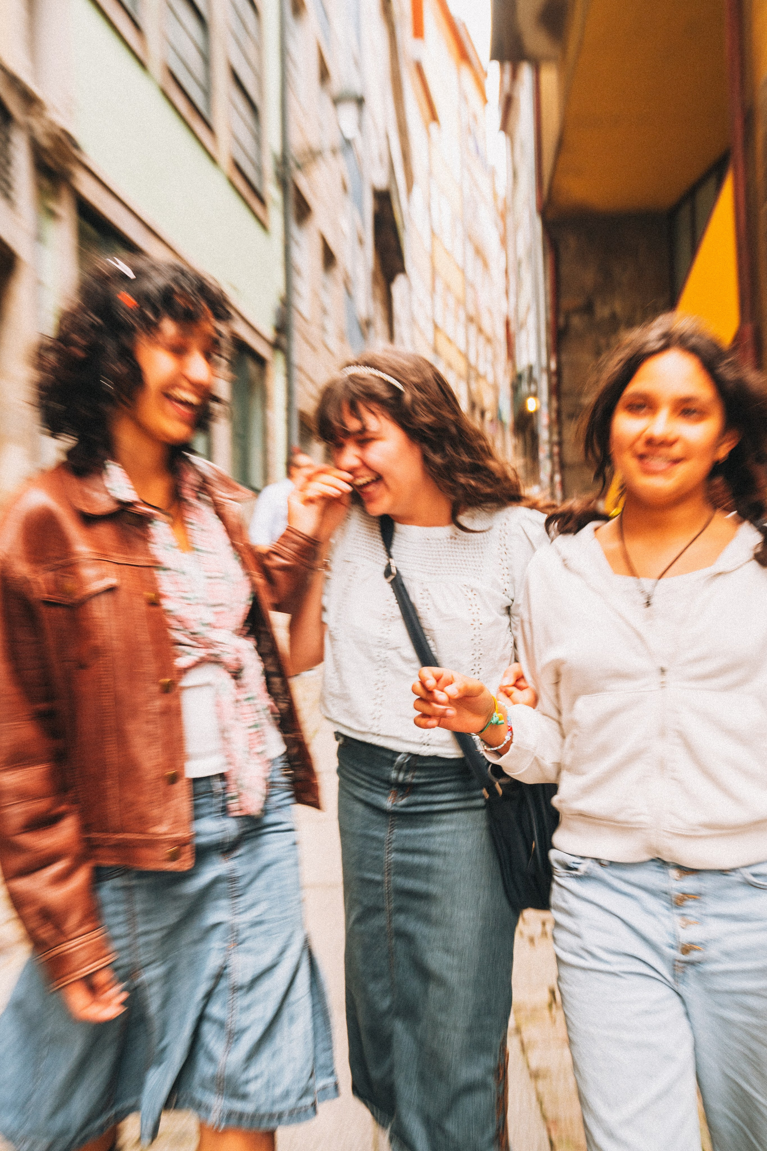 Группа людей семья влюбленные гуляет по живописной узкой улочке в Португалии, окружённой старыми домами и зеленью.