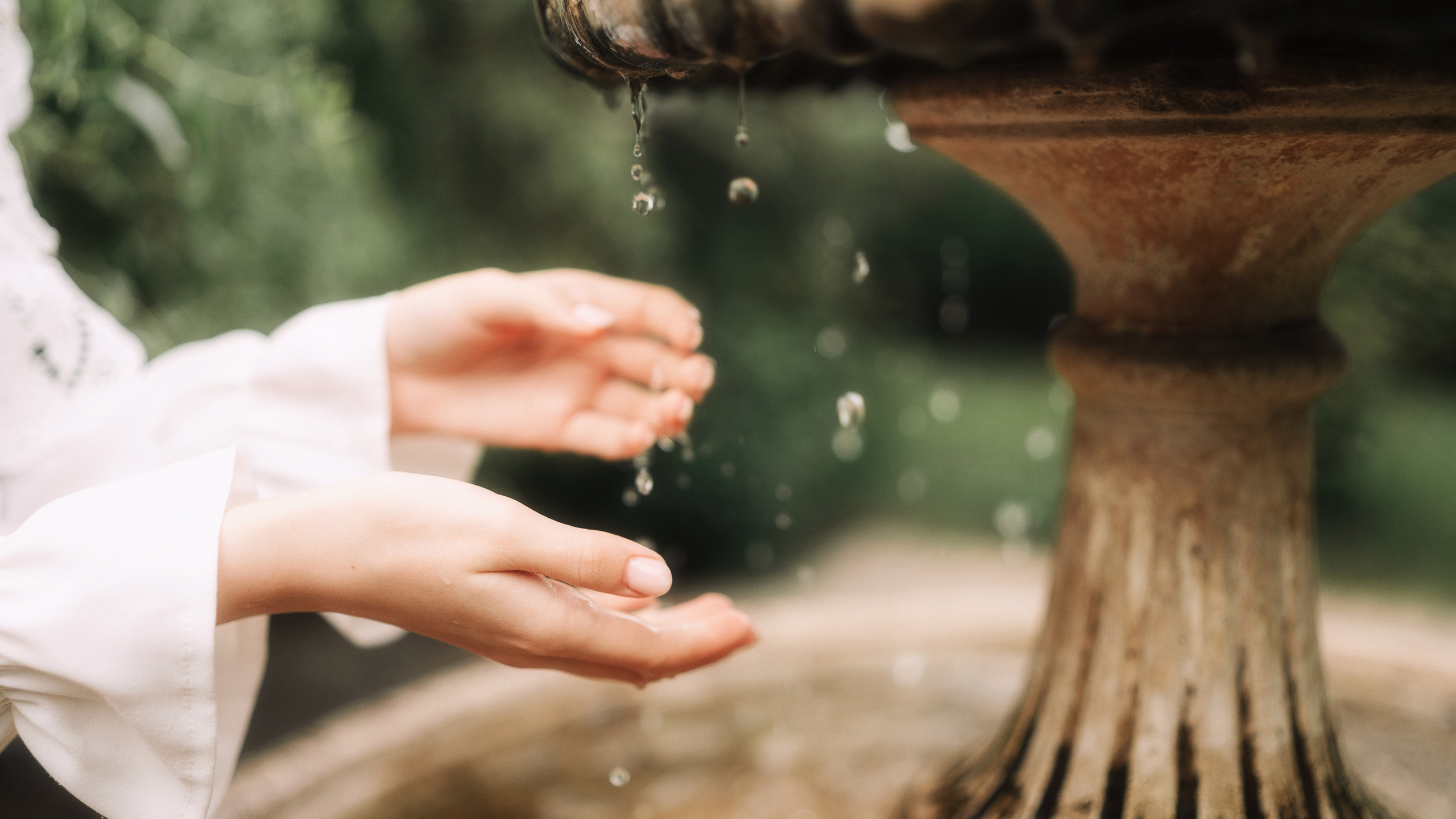 Фотографии рук у фонтана рыжей девушки.