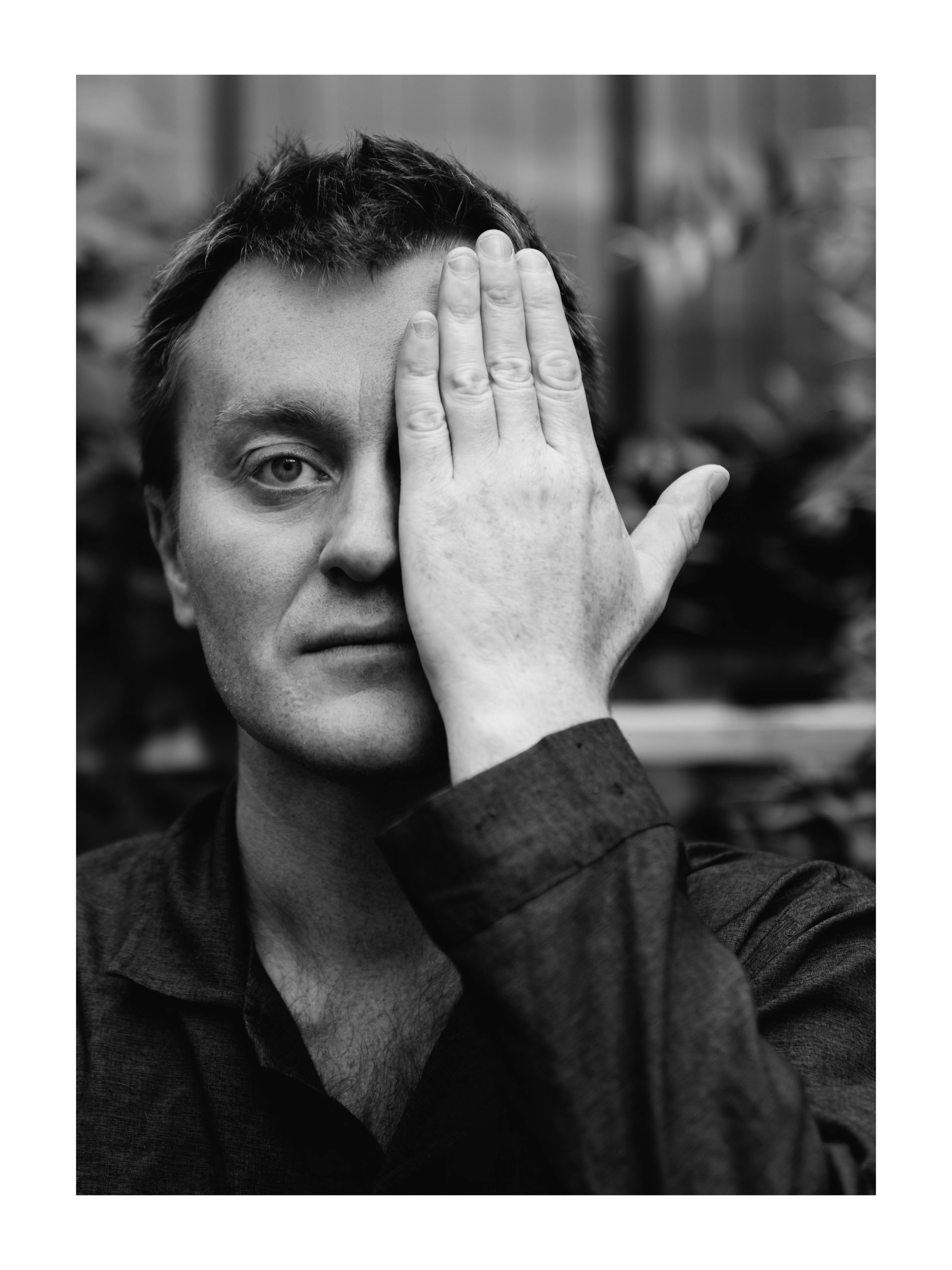 мужчина закрывает пол-лица ладонью