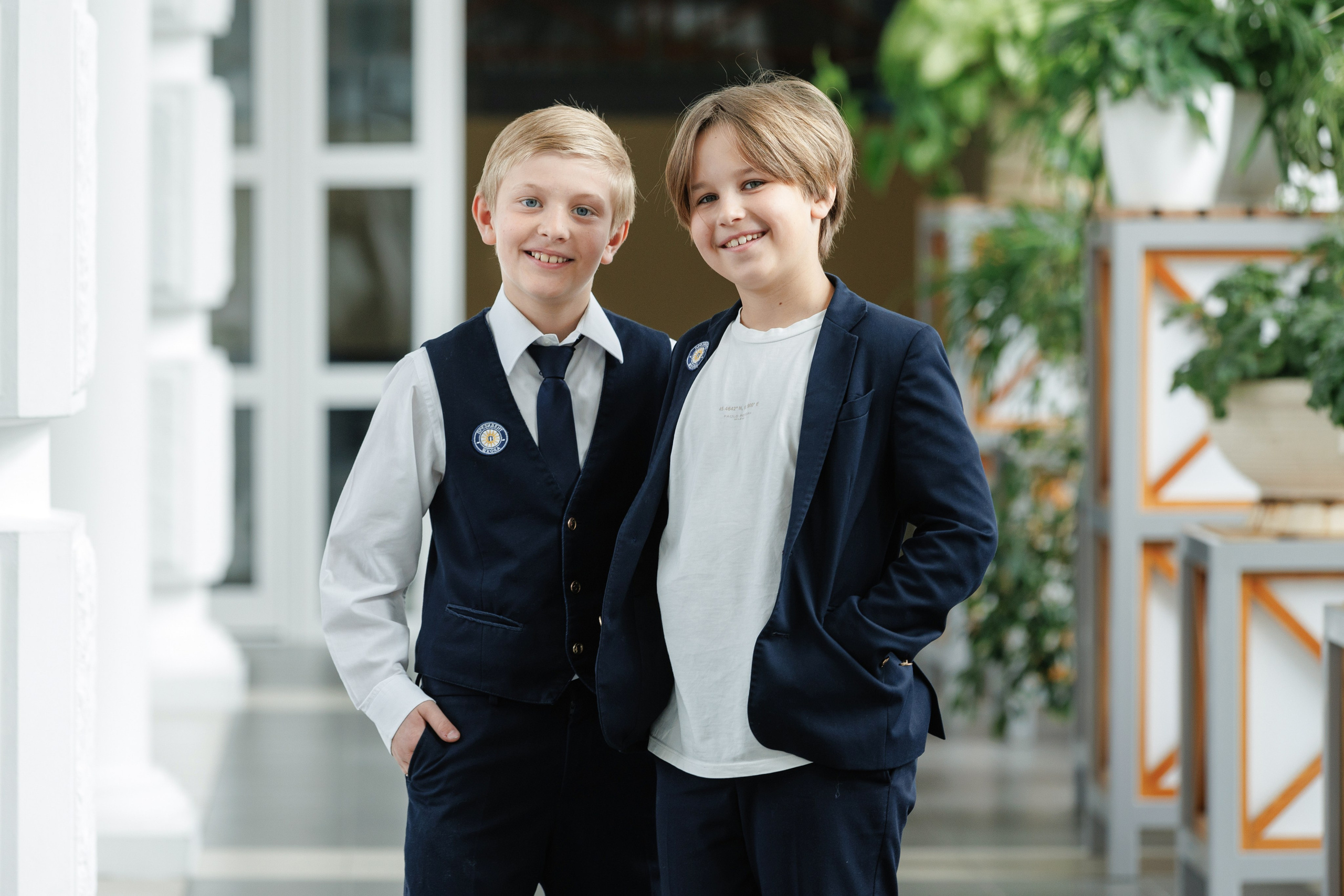 Два ученика в школьной форме в школьном коридоре