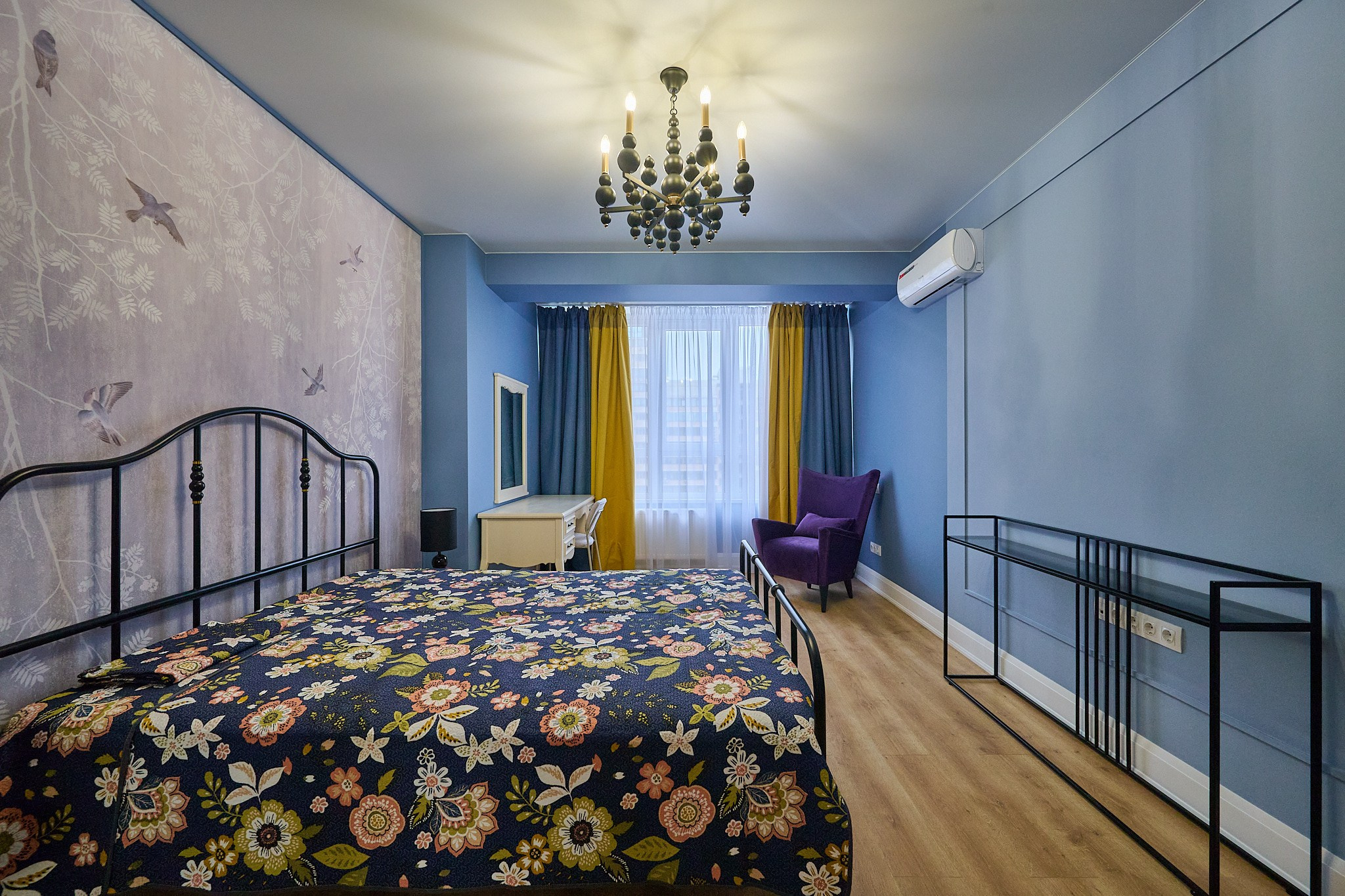комната голубая стенка окна кровать с интересным принтом и голубо желтые шторы 
