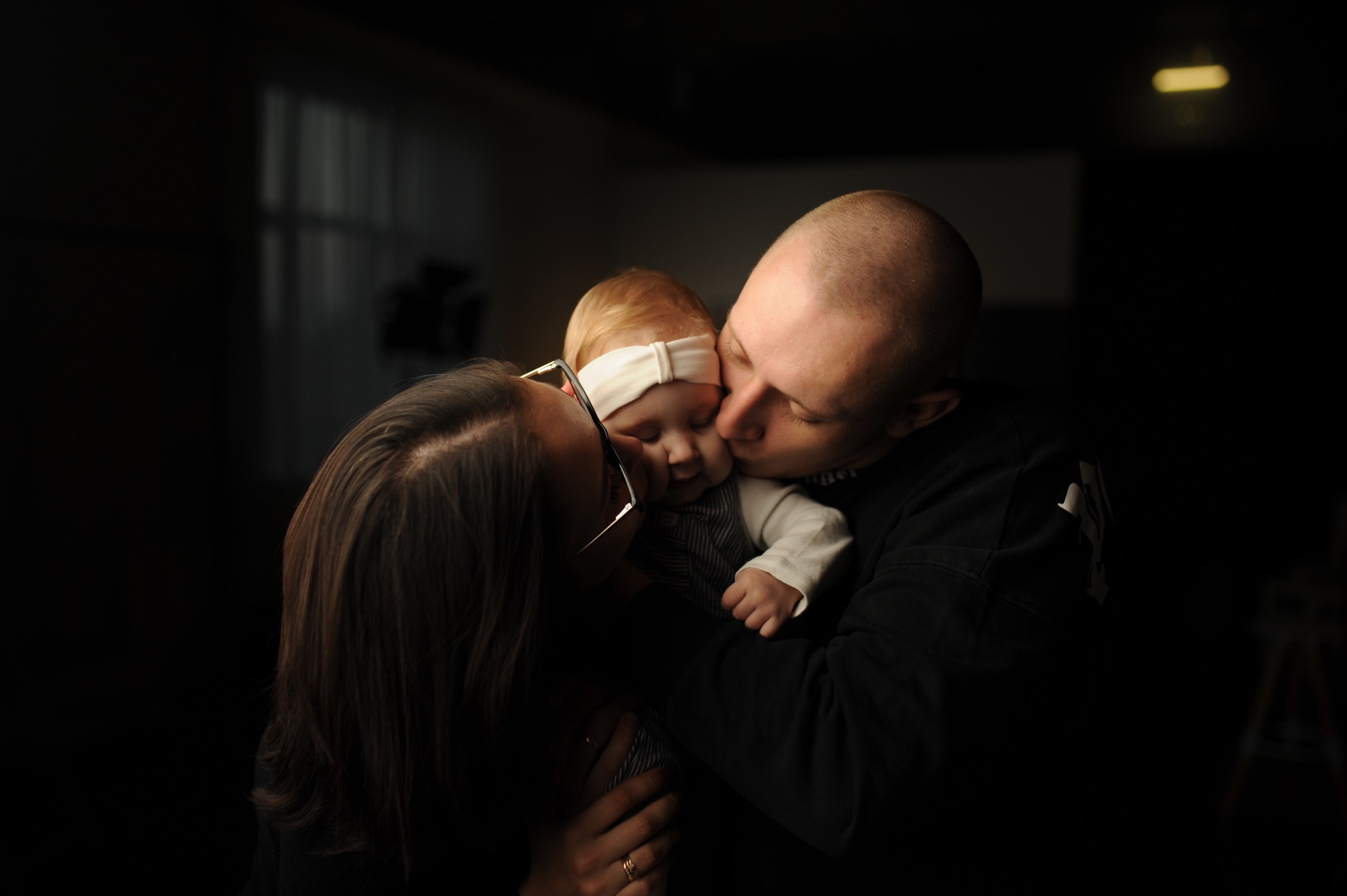 Семейная фотосессия в студии — мама, папа и ребёнок обнимаются