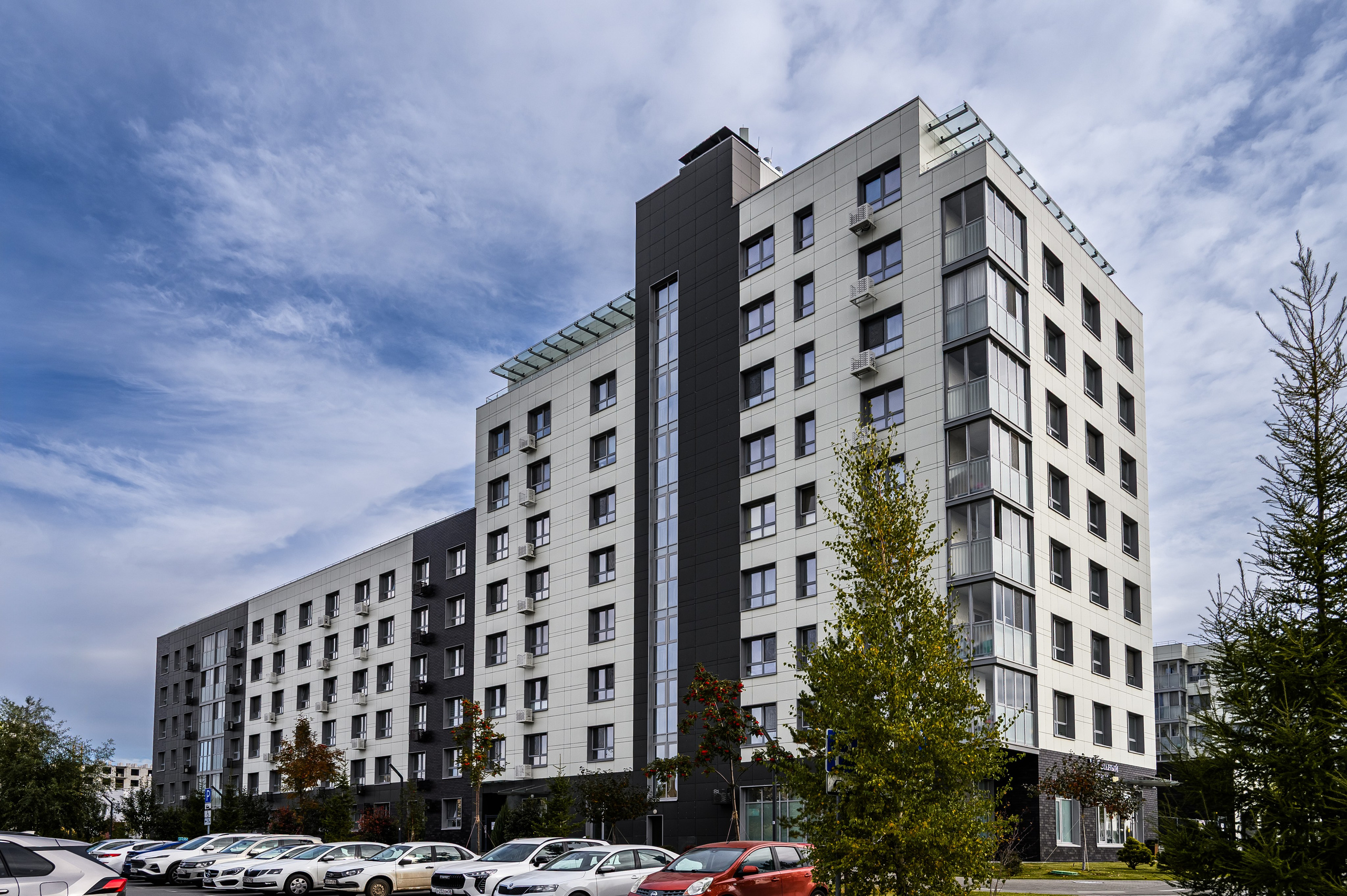 Вид на фасад жилого комплекса Лето в Казани с парковкой и зелёной зоной перед зданием, фото Алексея Клейменова