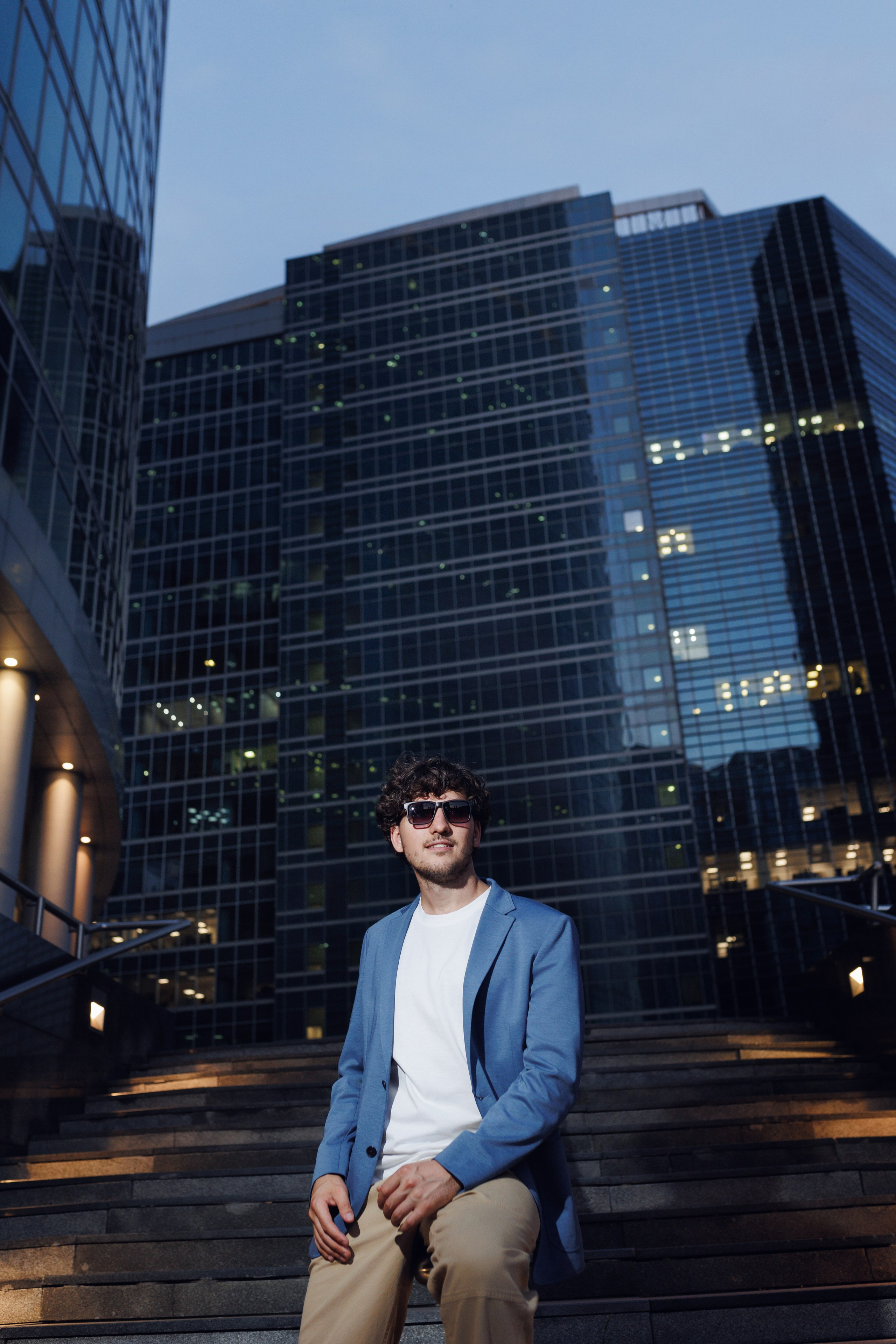 Расслабленная поза на перилах: мужчина созерцает панораму делового центра Москва-Сити. Съёмка в золотой час.