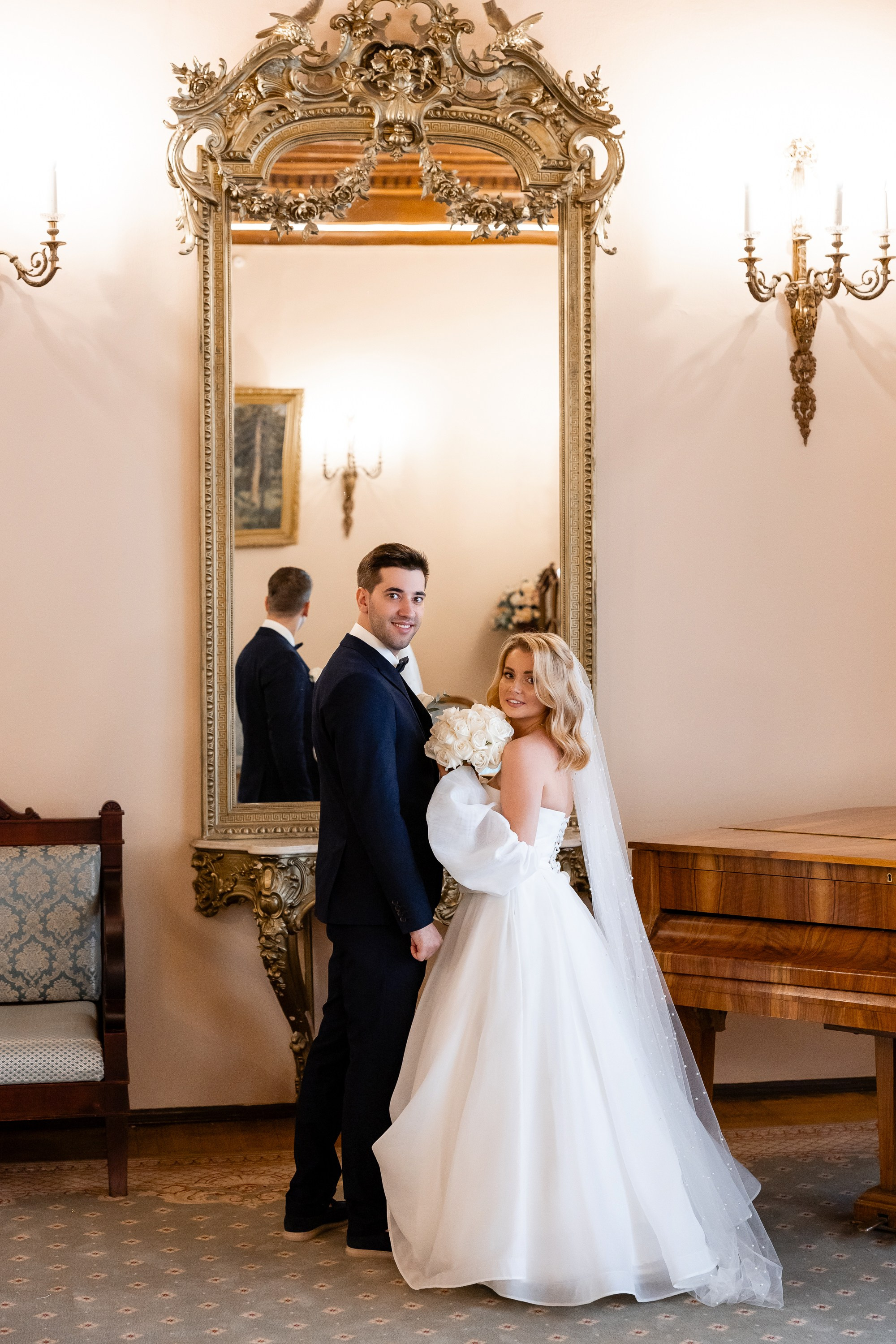 Фото жениха и невесты перед зеркалом в гостиной с роялем во дворце бракосочетания № 2 Санкт-Петербурга