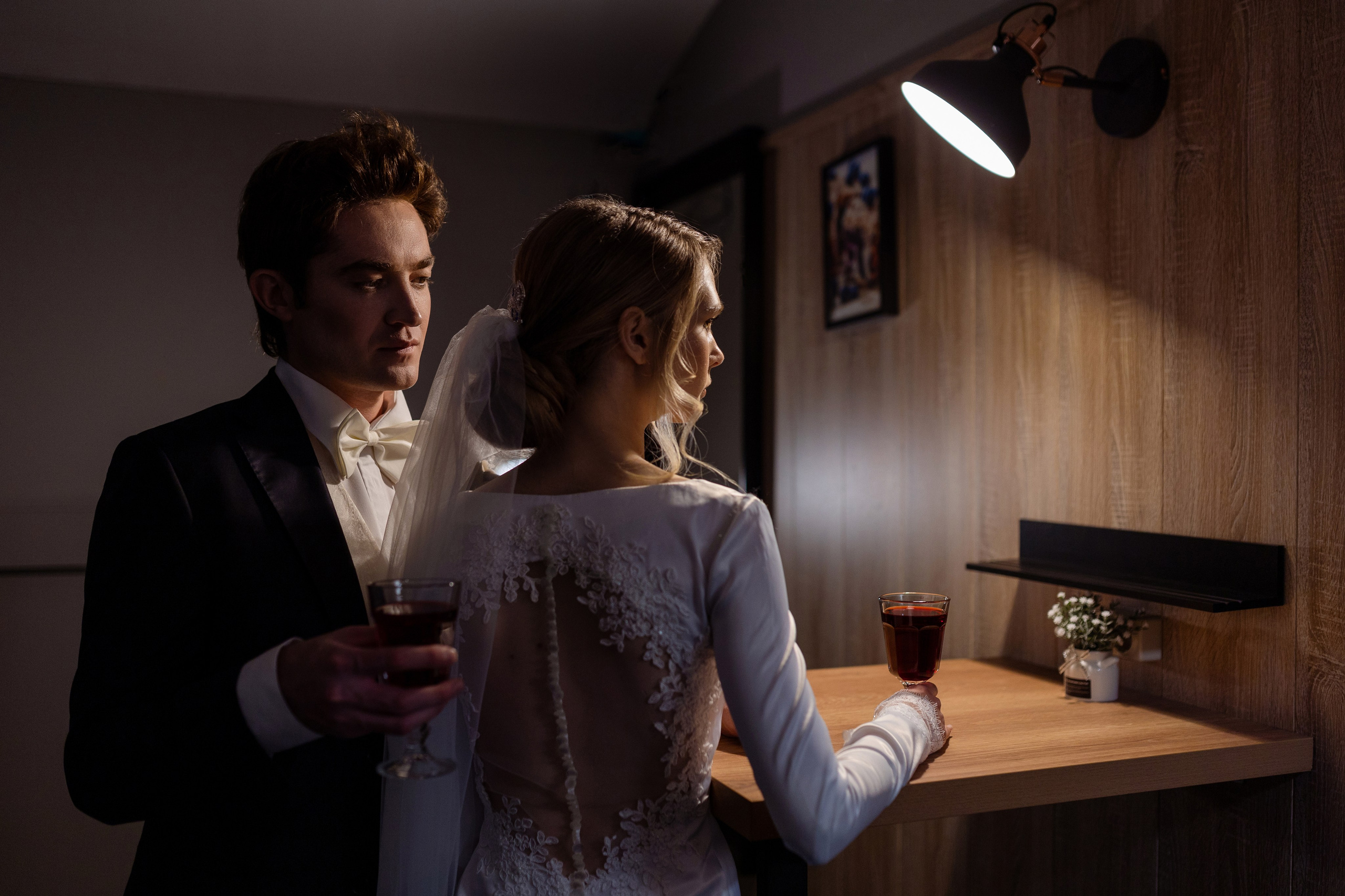 Жених с невестой у стола с бокалами в руках.