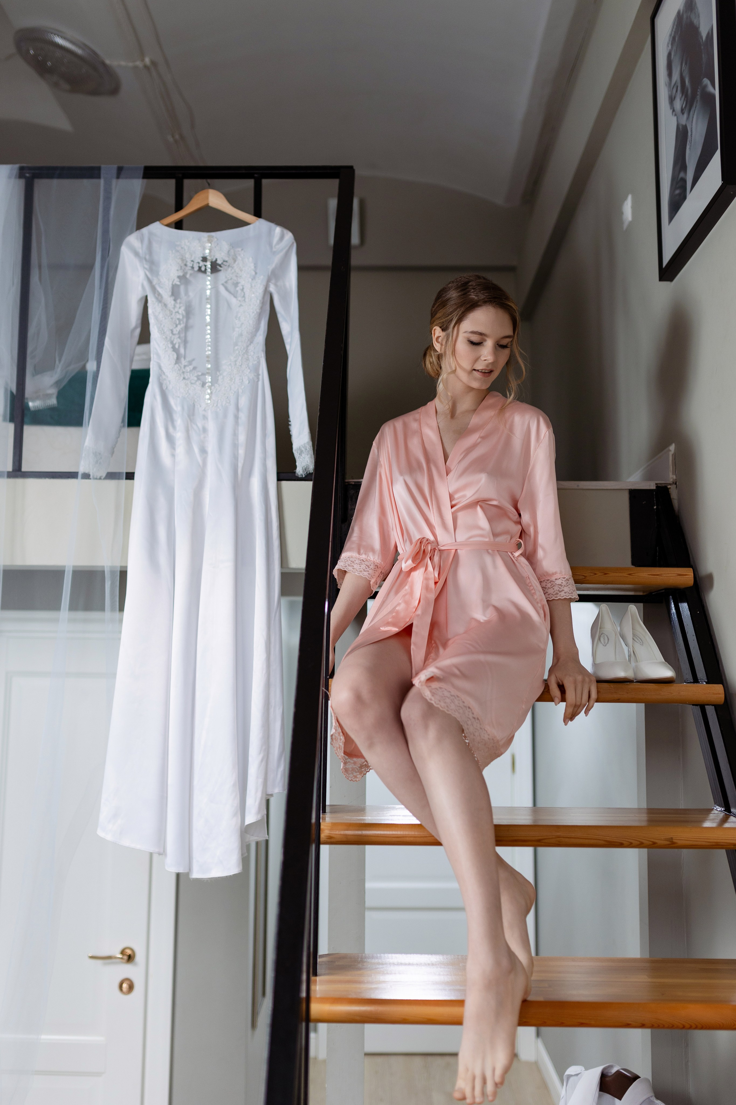 Невеста сидит на лестнице, на ступеньке стоят туфли 