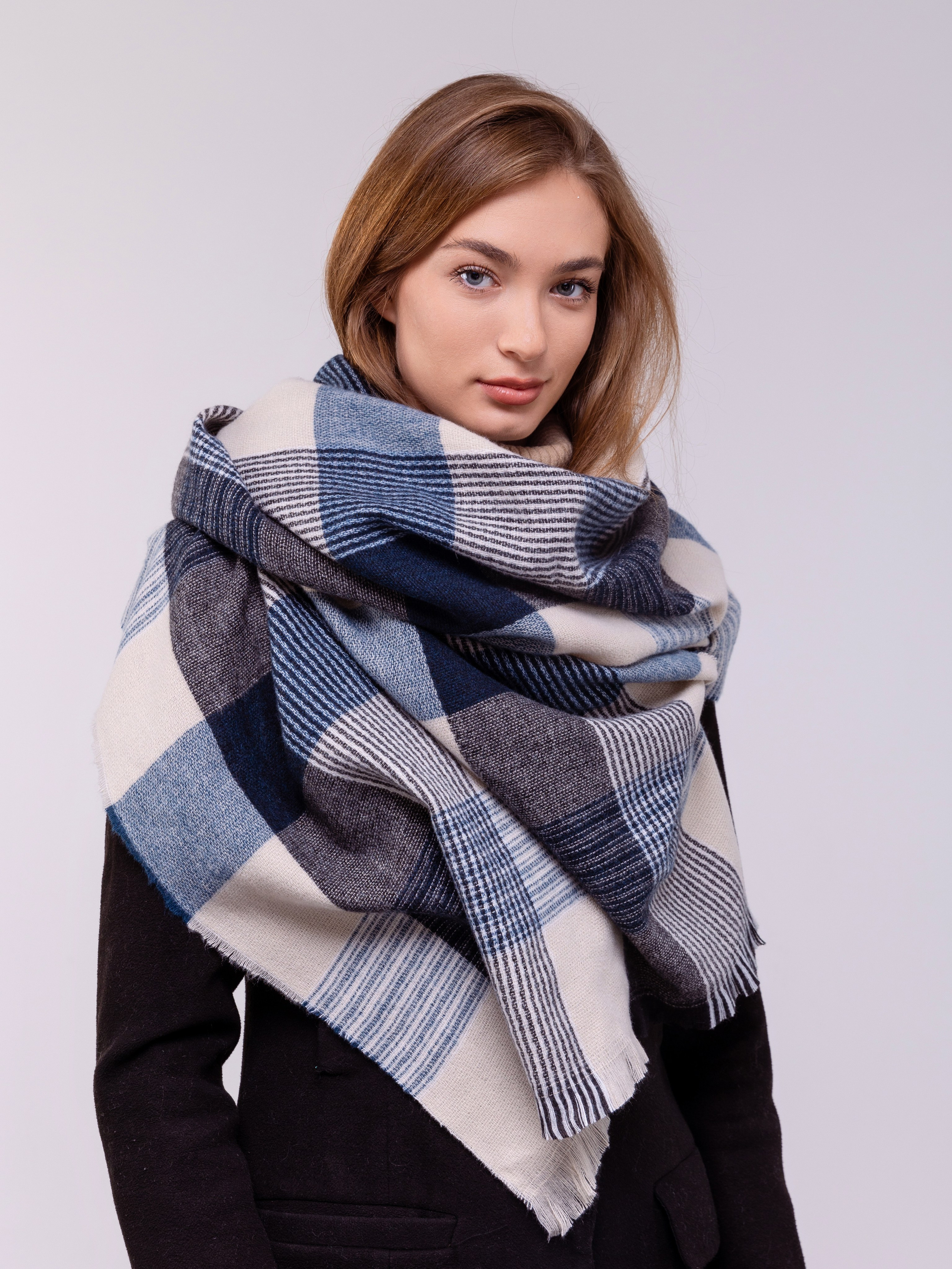 Палантин в крупную клетку вокруг шеи девушки. 