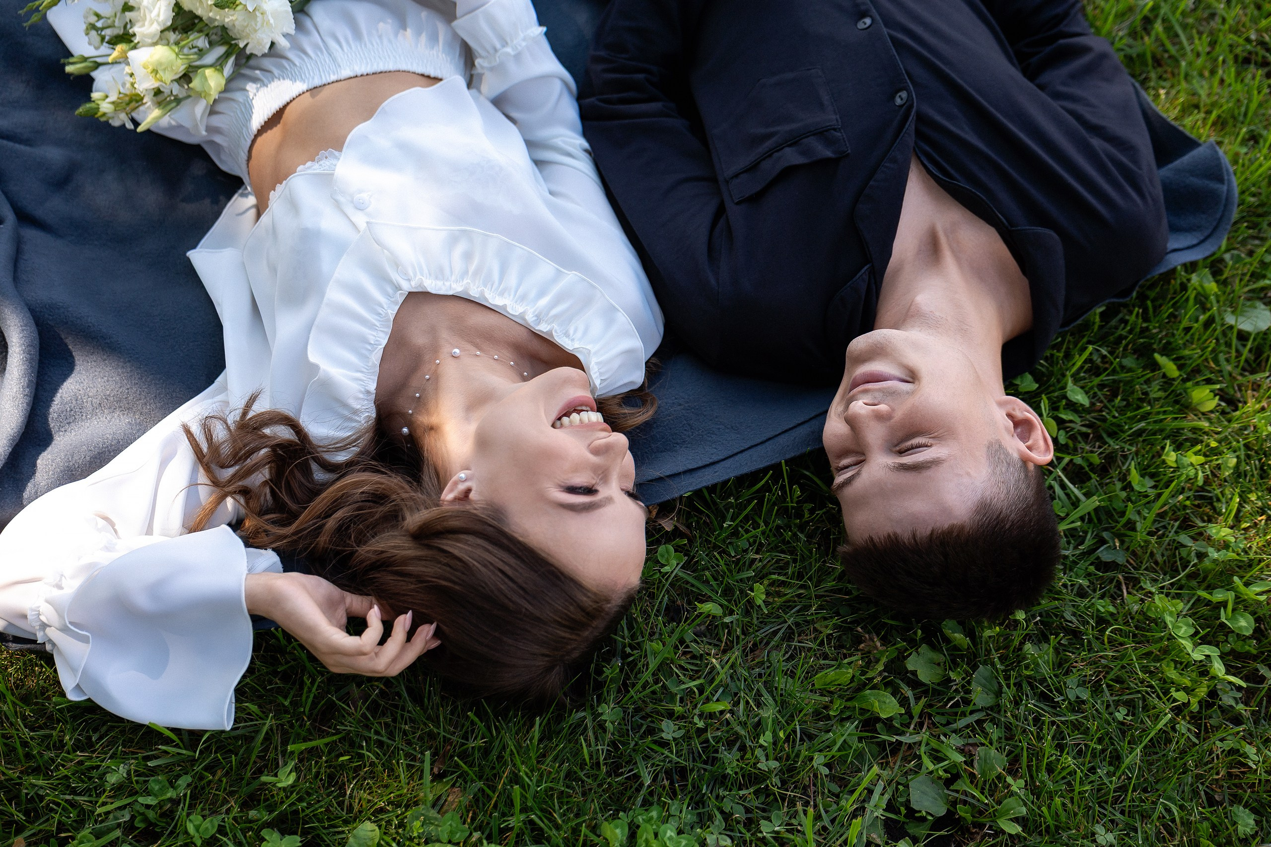 Совместное утро жениха и невесты, молодожёны в пижамах лежат на траве, эмоциональный живой кадр в объективе свадебного фотографа Сергея Ярилина в Самаре