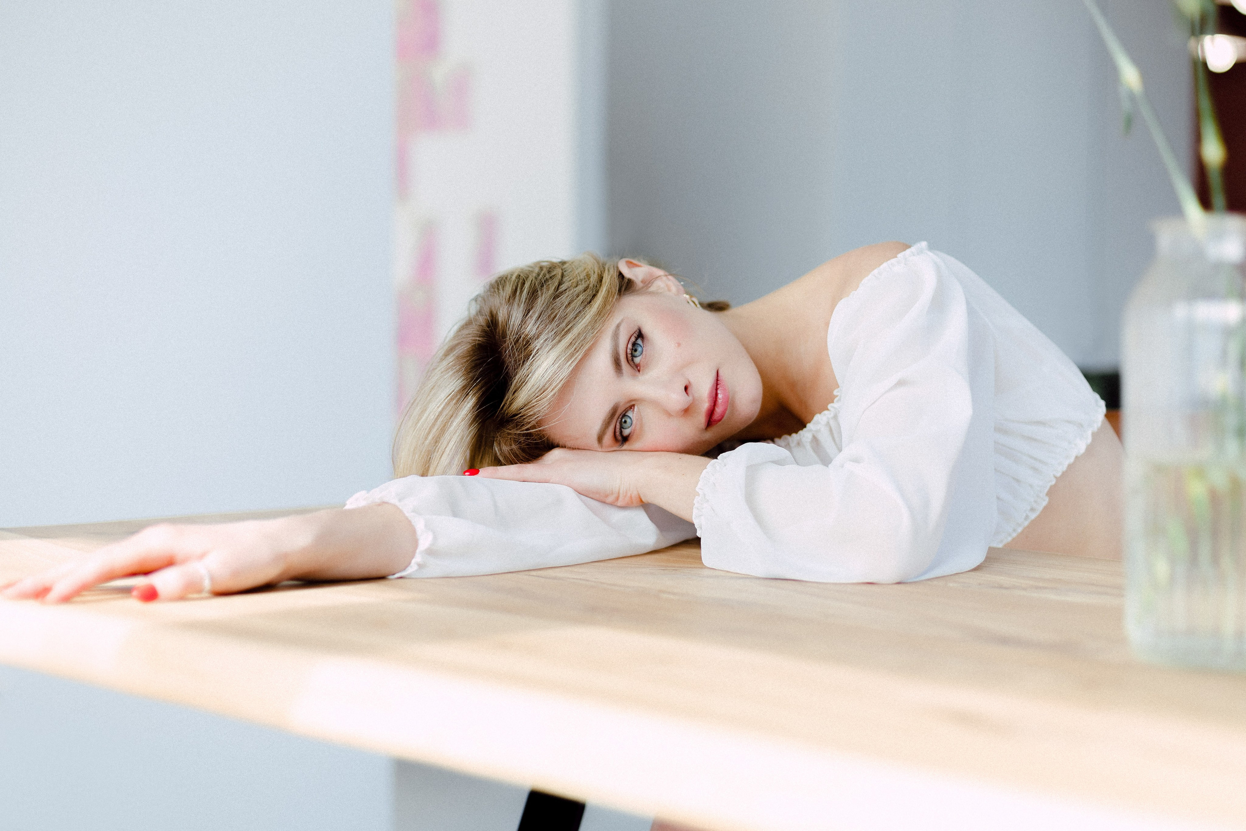 Фотосессия девушки в студии, девушка за столом