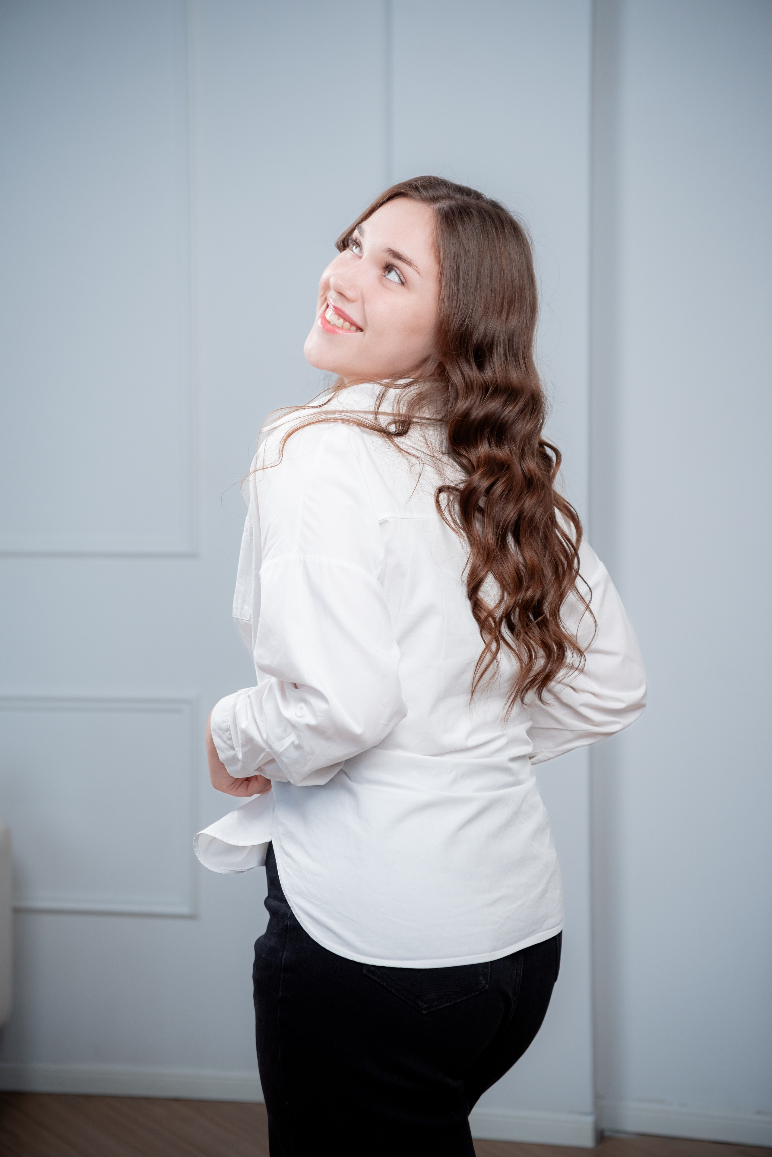 Портрет девушки в белой рубашке и чёрных джинсах